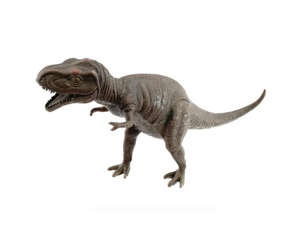 A large naturalistic cast bronze sculpture of a Tyrannosaurus Rex known as the king of the tyrant lizards modeled standing with an open mouth. The surface features hand-forged details and is covered with a deep brown patina. Collectible Tabletop