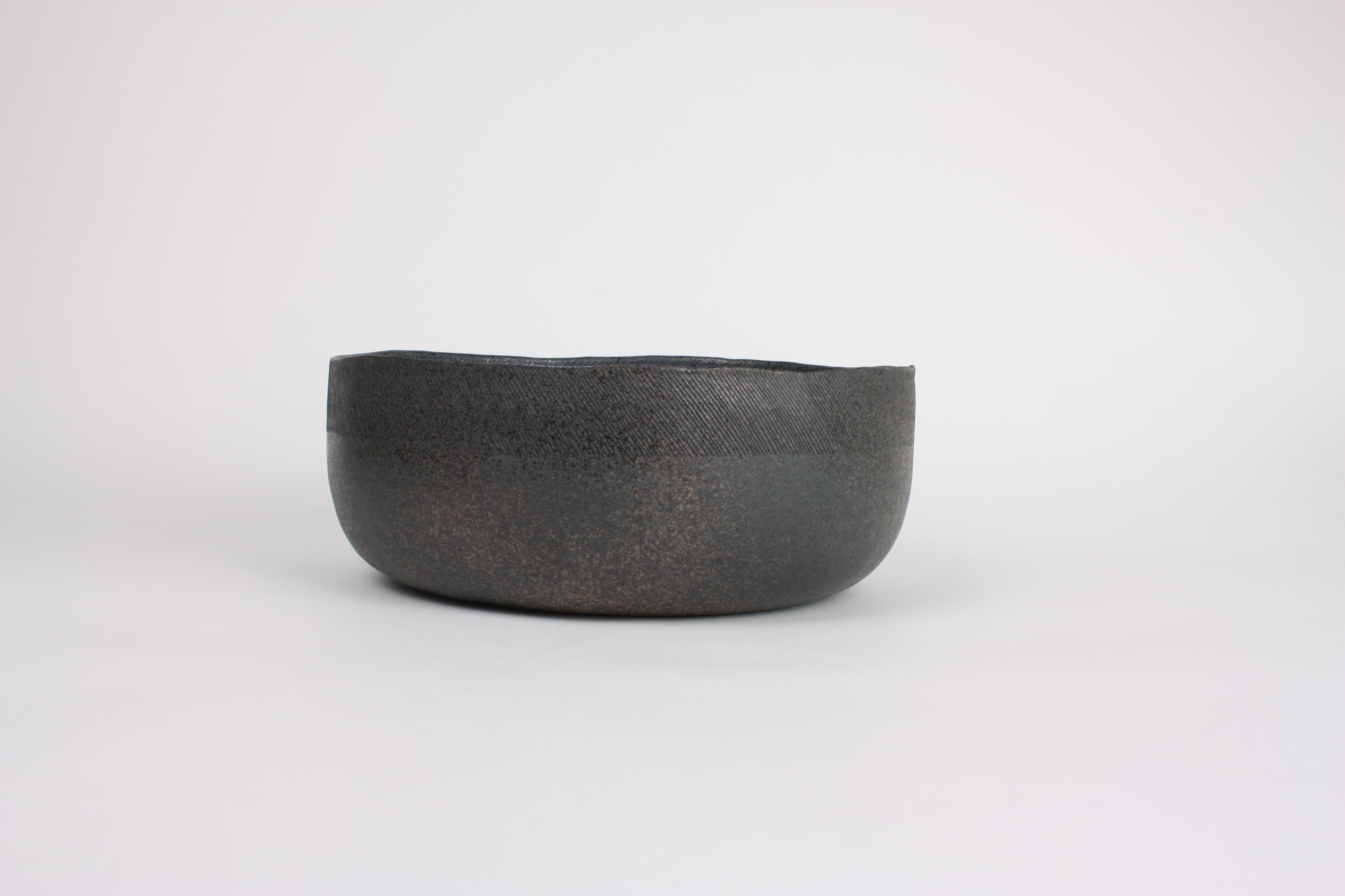 Large decorative contemporary stoneware flat bowl in gray tones. The thinness of this unglazed bowl can only be achieved using the technique of coiling. Built up from the bottom by integrating rolled ropes of clay one at atime, the bowl slowly takes