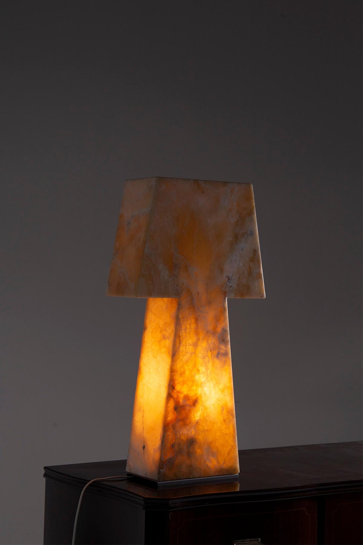 Imagine entering a room adorned with the pure embodiment of refinement and craftsmanship. A magnificent contemporary piece from the heart of Made in Italy, this contemporary table lamp is a testament to timeless elegance. Carved from exquisite onyx