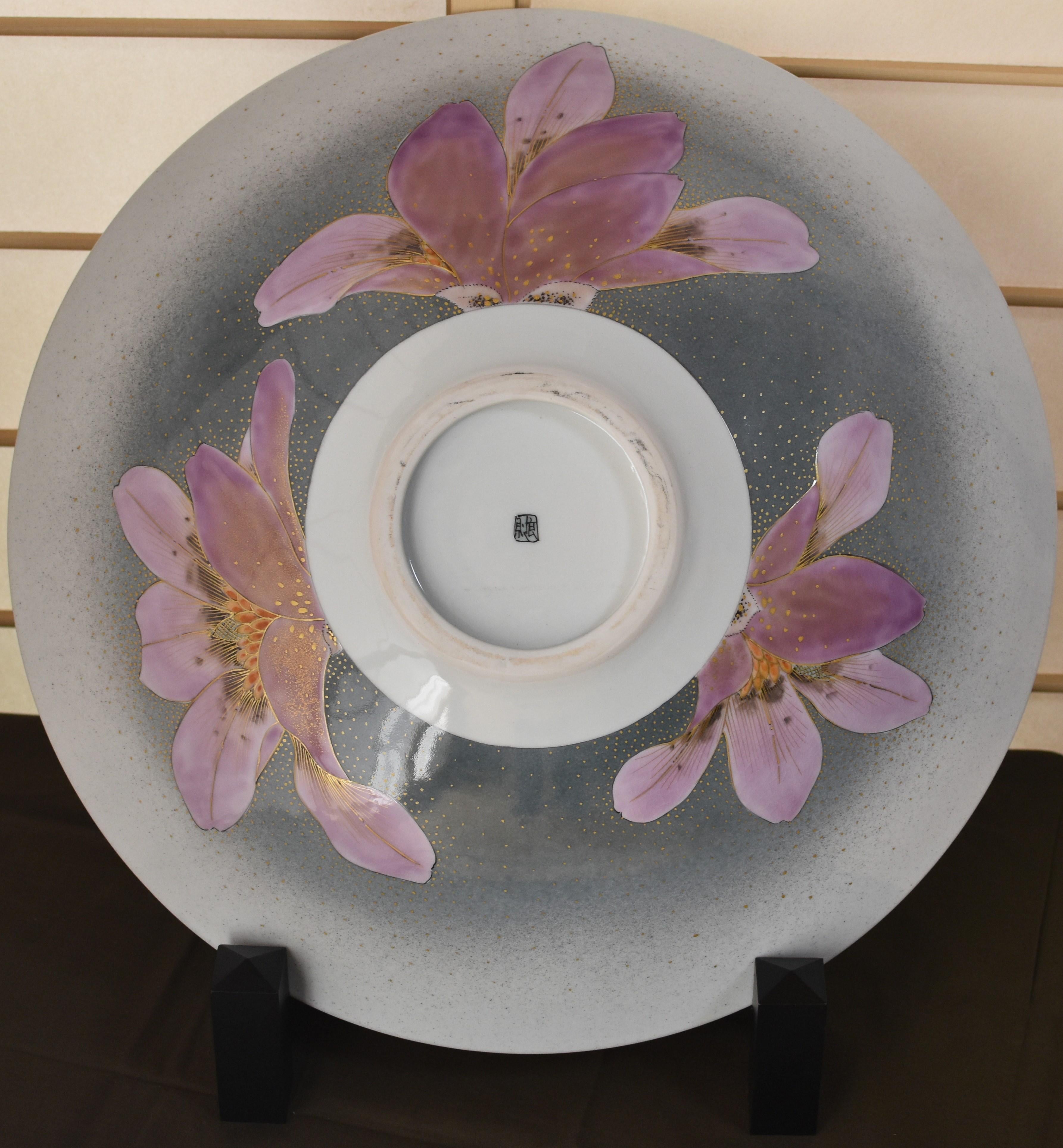 Breathtaking very large Japanese hand-painted contemporary decorative porcelain deep charger/centerpiece showcasing bold dramatic pink/purple magnolia flowers in full bloom on a beautiful background of stunning gradations in gray decorated with gold
