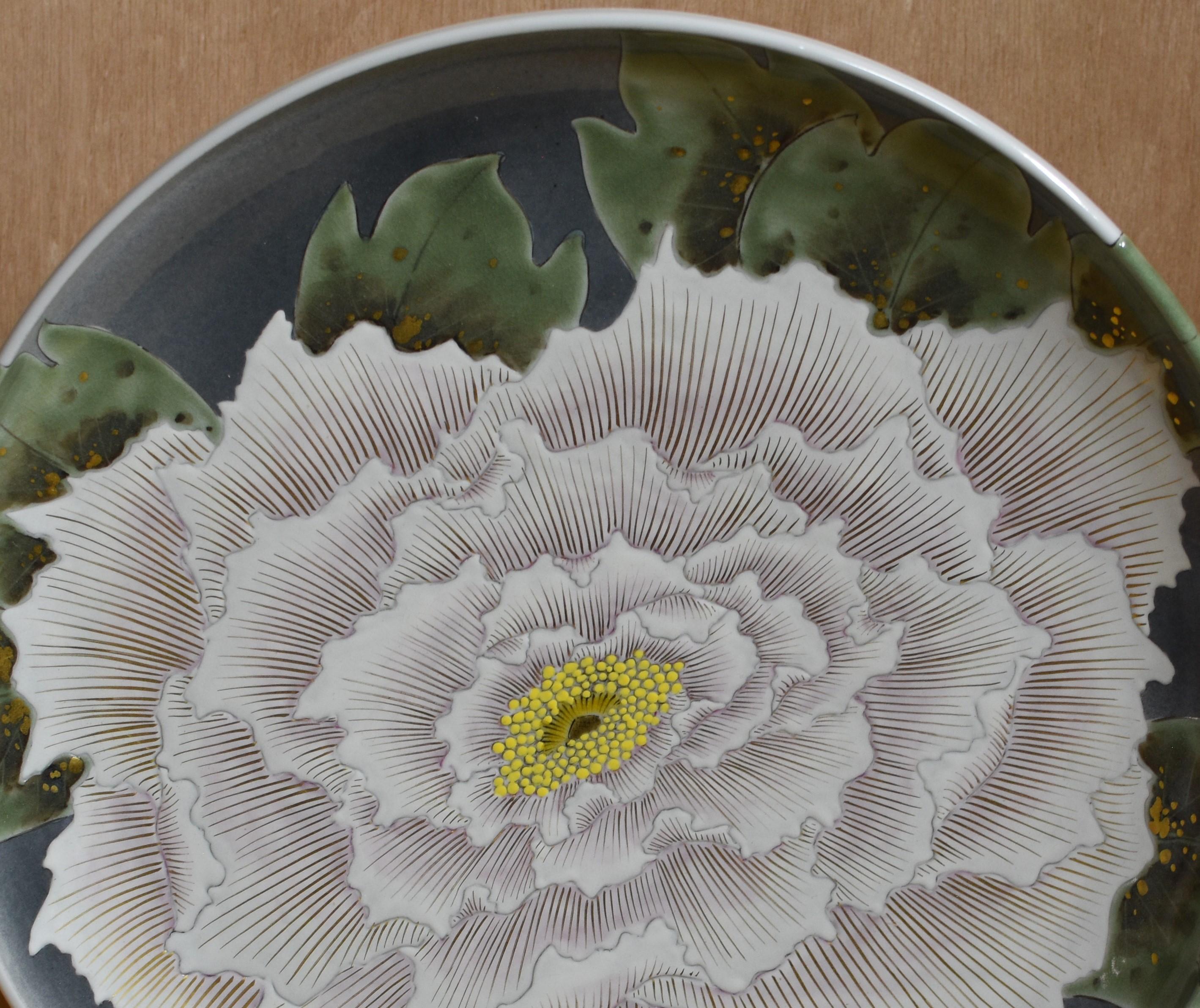 Extraordinary Japanese large contemporary decorative Kutani porcelain deep charger/centerpiece, extremely intricately hand painted in an attractive cream color on different hues of green. It is a masterpiece by a Kutani master artist whose signature