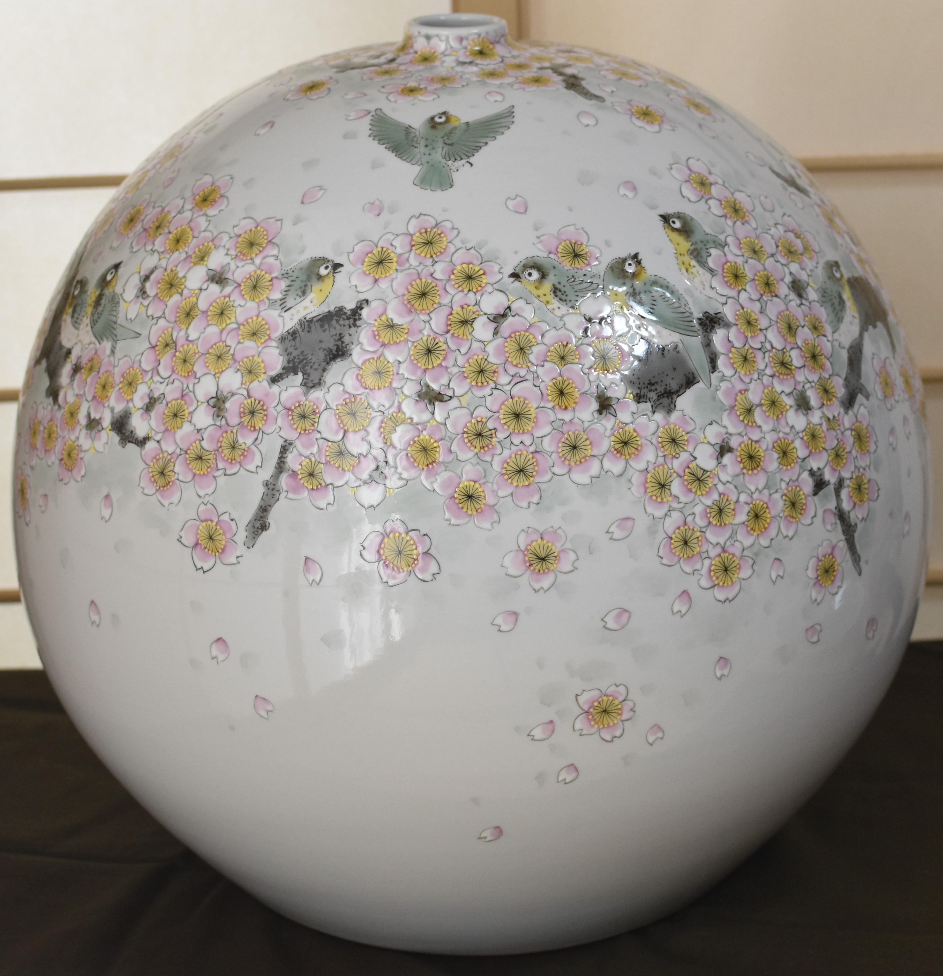 Extraordinary large contemporary Japanese decorative porcelain vase, intricately hand painted in beautiful cream, pink and green, creating a stunning two wide band of cherry blossoms in soft pink and graceful birds decorating the center and rim of