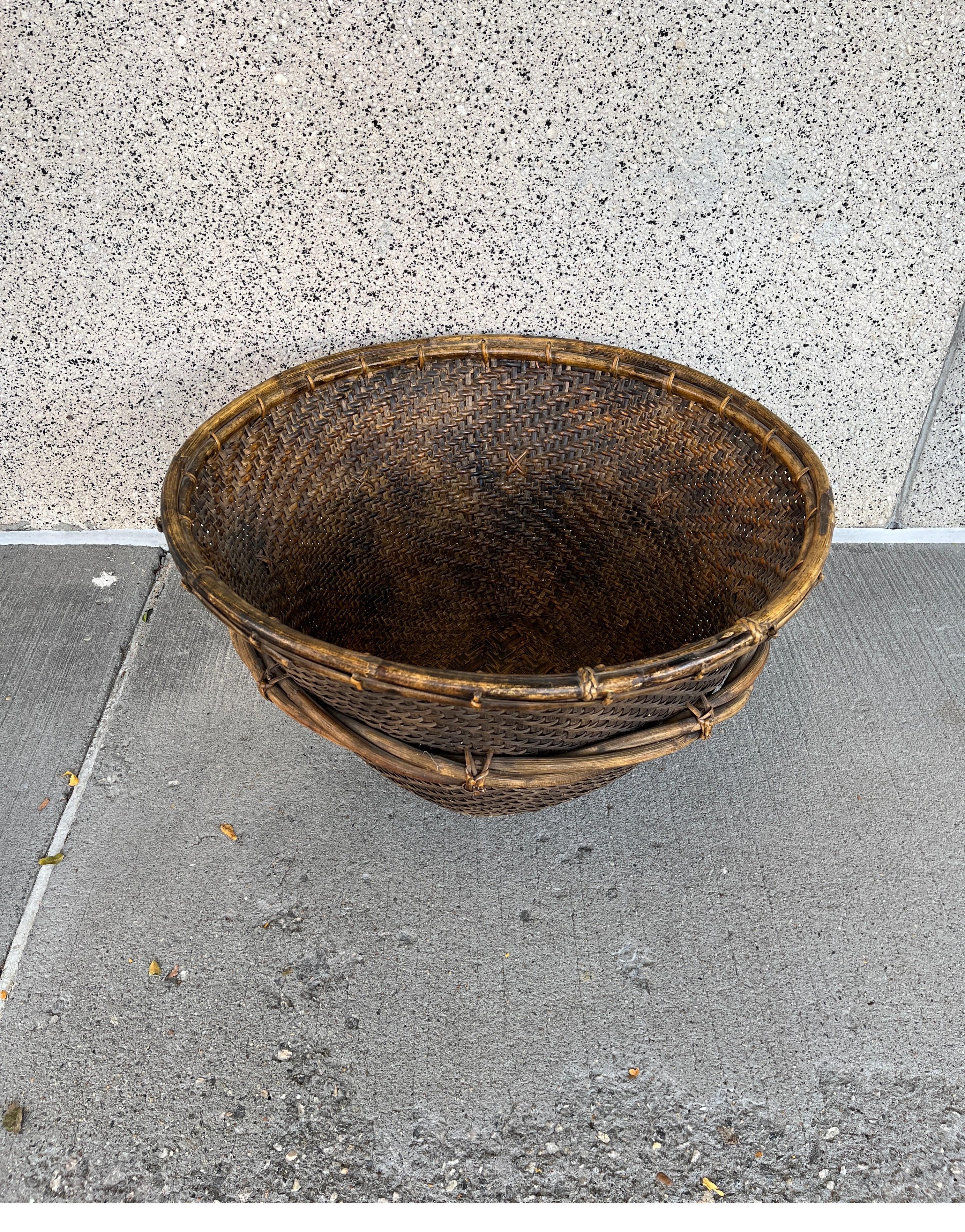 A beautiful and expertly hand woven natural fiber and wood basket. This large piece features striking bamboo accents at the top and in the middle of the basket. A versatile and practical container that will add warmth to any room. An entirely