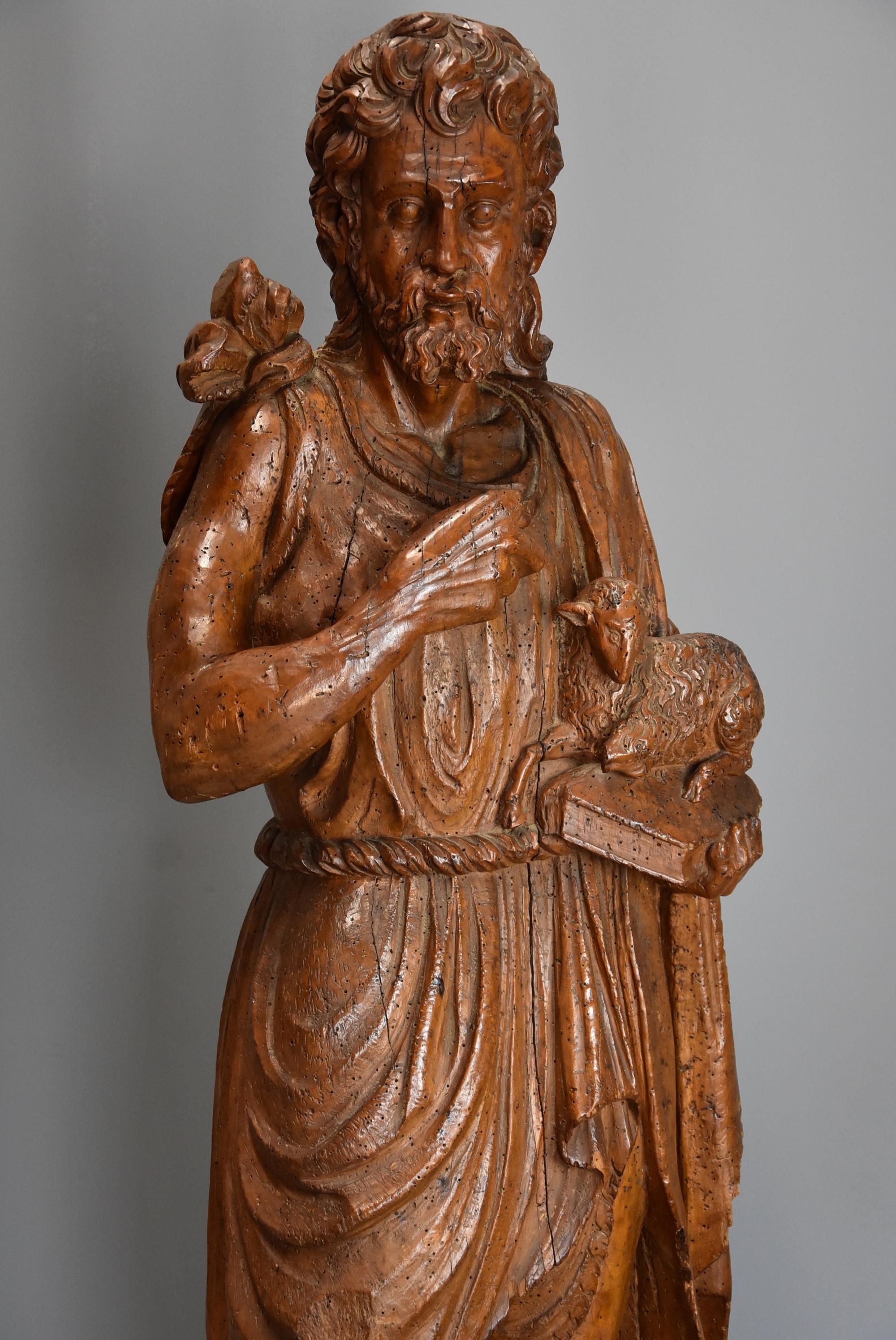 A large Continental mid-16th century (circa 1550) carved limewood figure of St. John the Baptist.

St. John is stands in a draped robe holding a book with a lamb upon it, all supported on later wooden plinth with moulded edge.

St. John is often