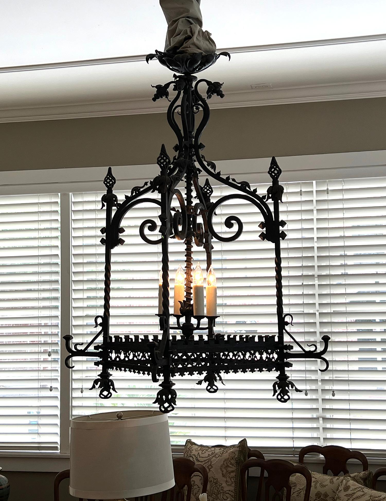 With vasi-form top above a four-sided open frame topped with spiraling finials resting on twisted supports ending in similar spiraling pendants all joined by an openwork trefoil perimeter border; all surrounding a later 4-light cluster.
