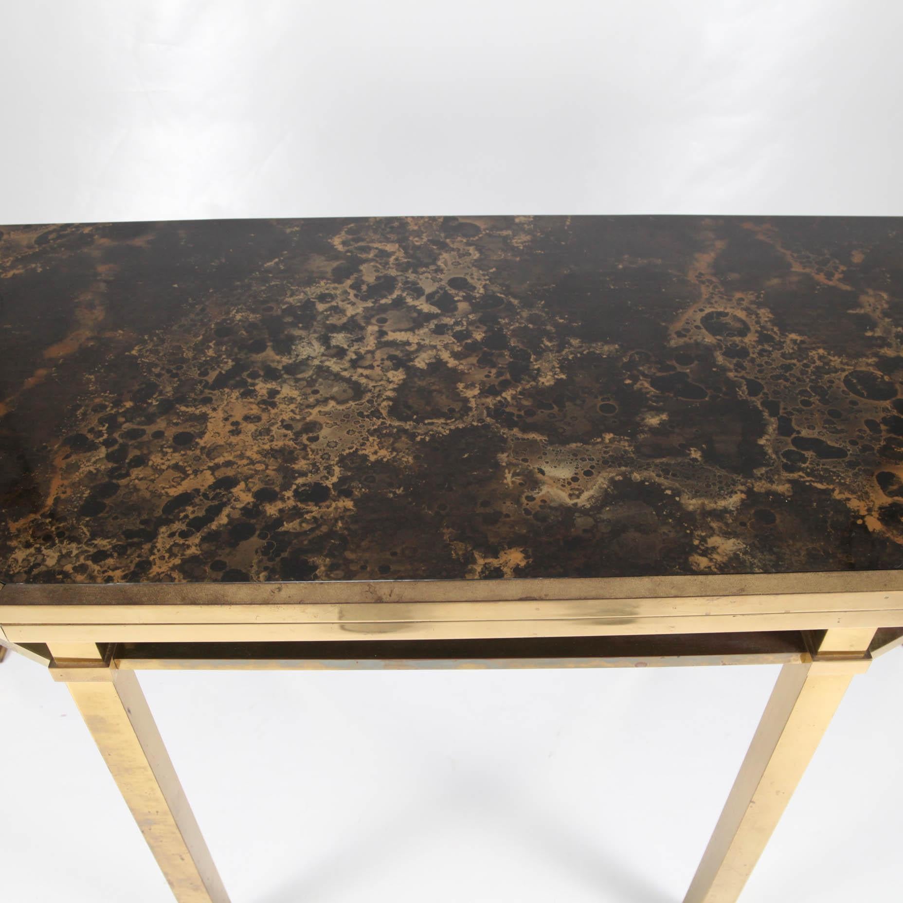 Large convertible console table by Maison Jansen circa 1970 with brass legs and stratified top. When closed, you will have stratified work with brown and gold color which is an unique technique to immitate lacqured effect that Maison Jansen use for