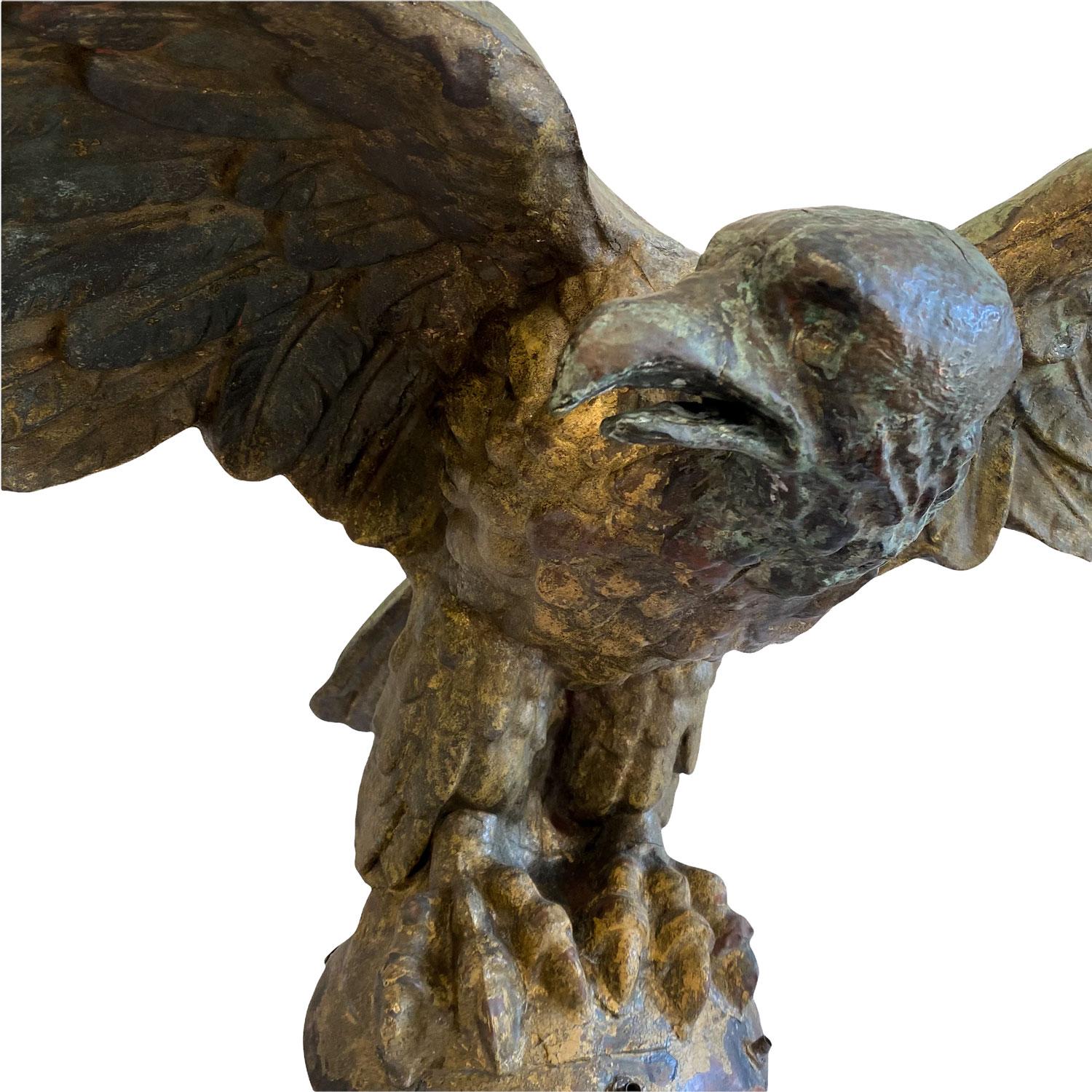Spread wing eagle perched on a sphere, molded copper, with a great gilded surface on the front. The back has a nice natural veridigris, American, Late 19th early 20th century. Purportedly sat a top of a Delaware bank. Measures: 23