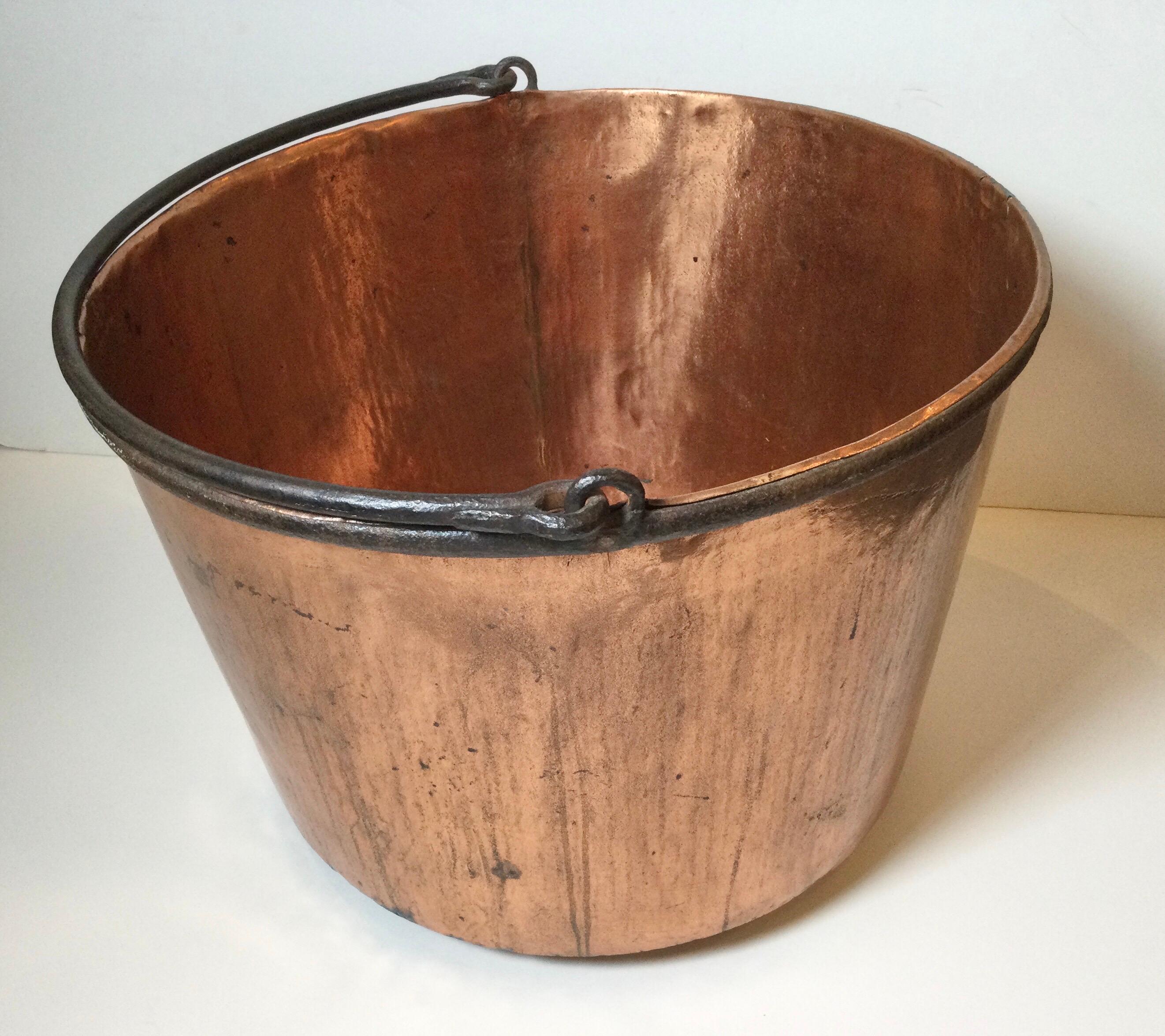 Large antique hand made copper and iron pot caldron with tong and groove construction. The handle and attachments made of hand forged iron.