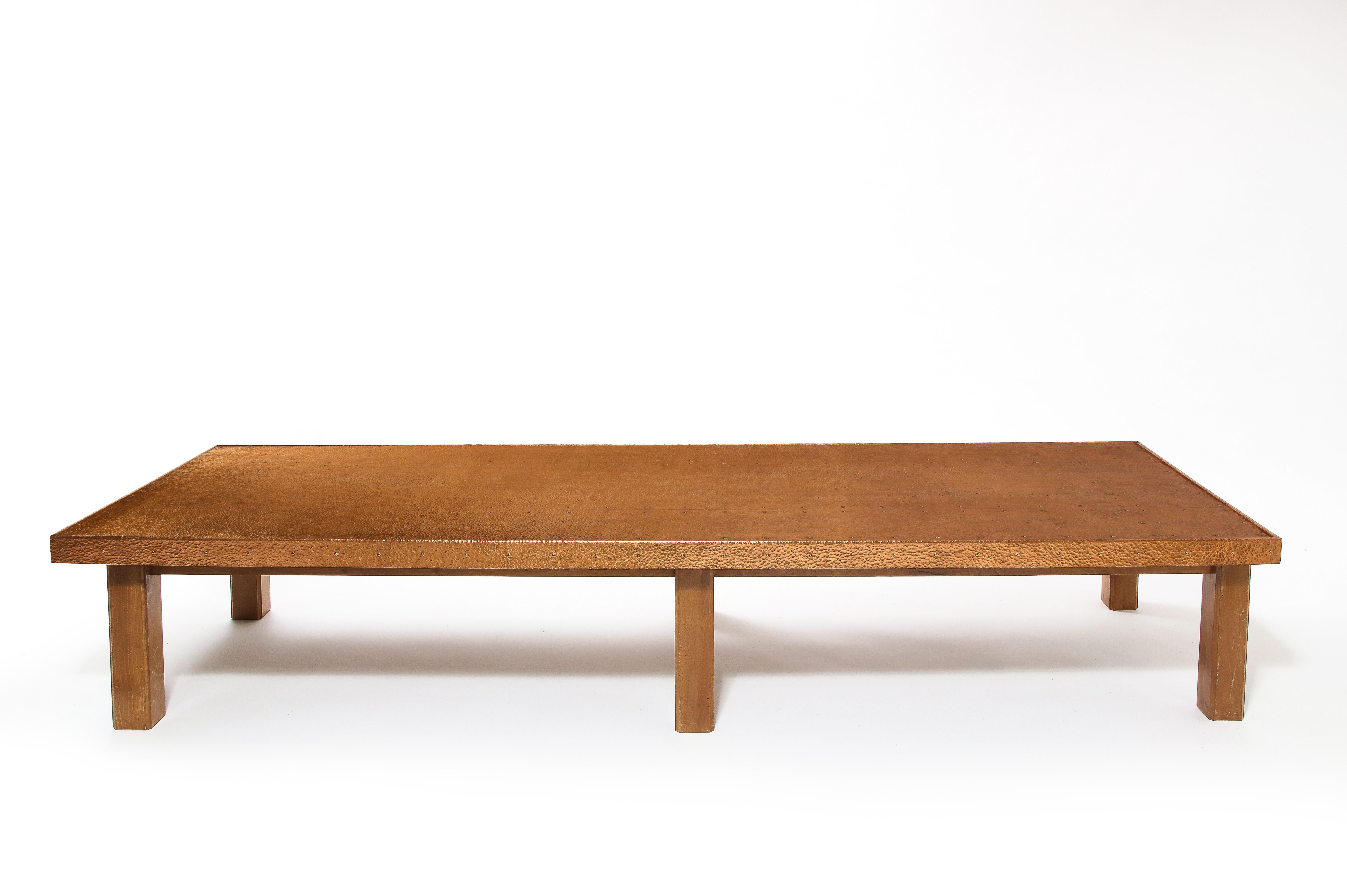 A large coffee table in elm with a solid copper top it made of a thick bent sheet of copper and is ballpoint hammered throughout.