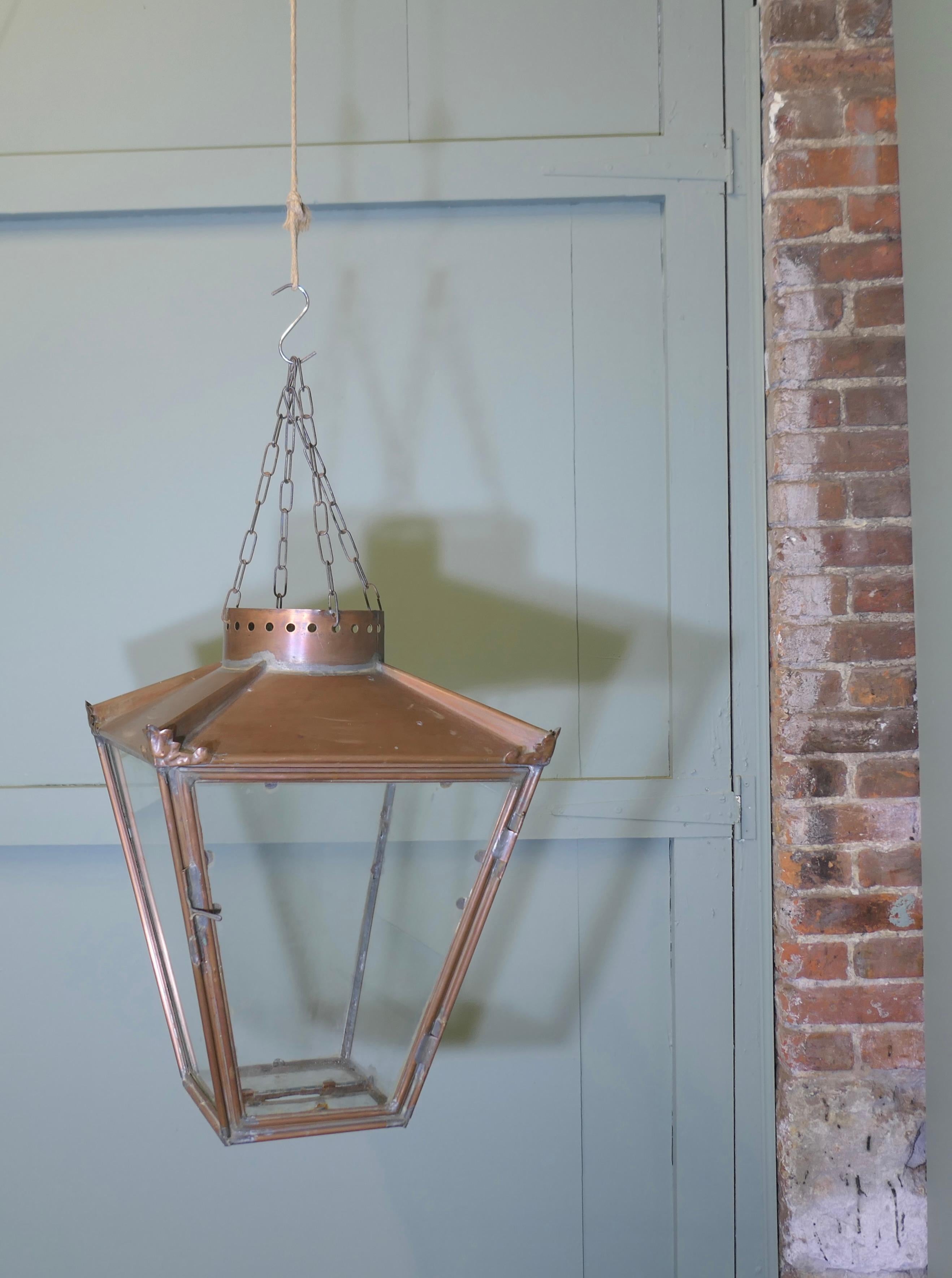 Abat-jour pour lanterne suspendue en cuivre 

Cet abat-jour suspendu a la forme d'un grand lampadaire en cuivre, la lanterne a une patine naturelle oxydée, 
il est vitré sur les côtés et à la base et est suspendu à 4 chaînes par le haut
Le travail