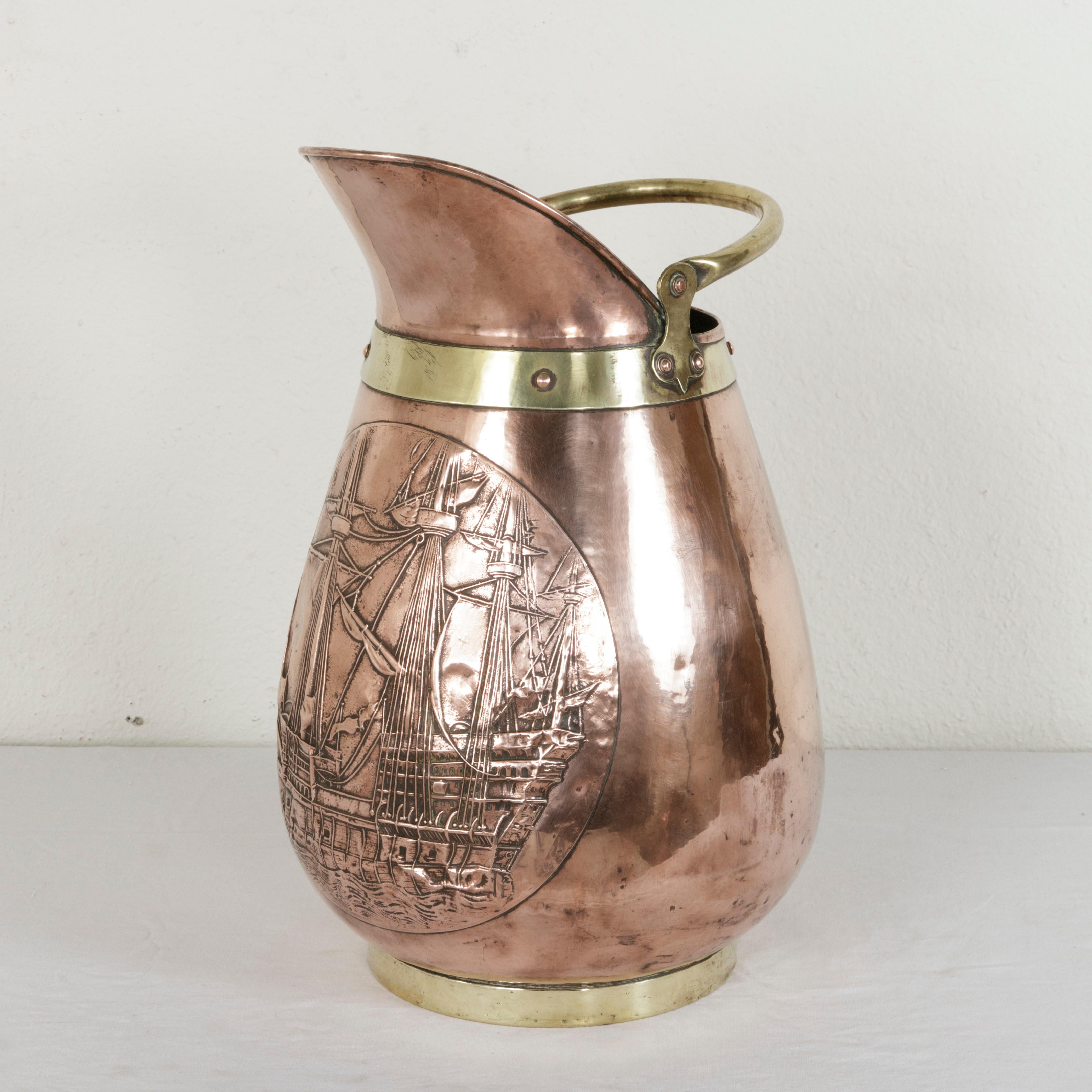 This very large French copper repousse pitcher from the mid-20th century features a nautical scene of a tripled masted galleon, a 17th century type of ship. Copper riveted brass banding surrounds the base and top, and a brass handle allows for easy