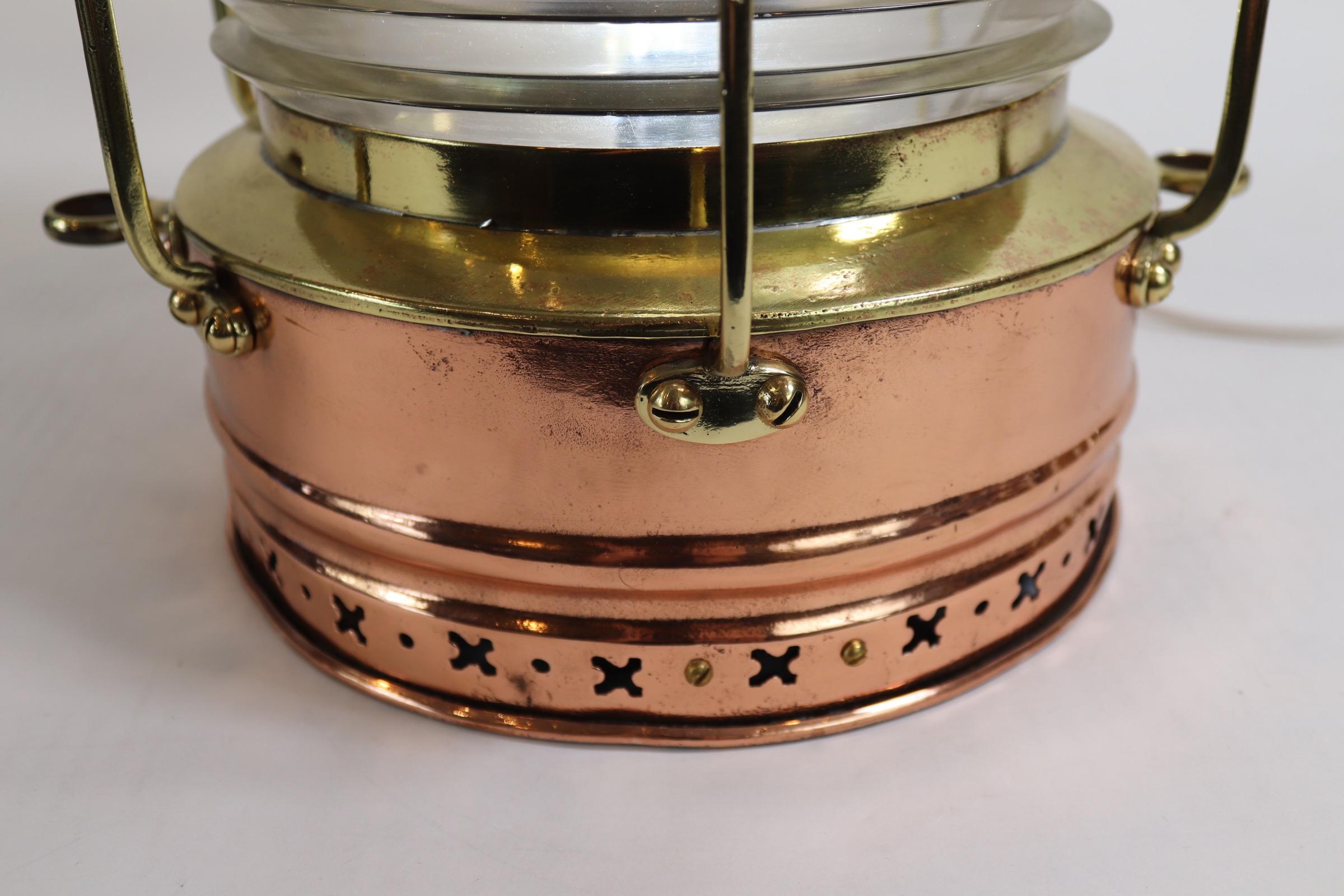 Large copper ships lantern with brass makers badge from the firm of Hugh Douglas of Liverpool. Lantern is highly polished and lacquered, fitted with a fresnel glass lens that is surrounded with protective brass bars. Wired with electric for home