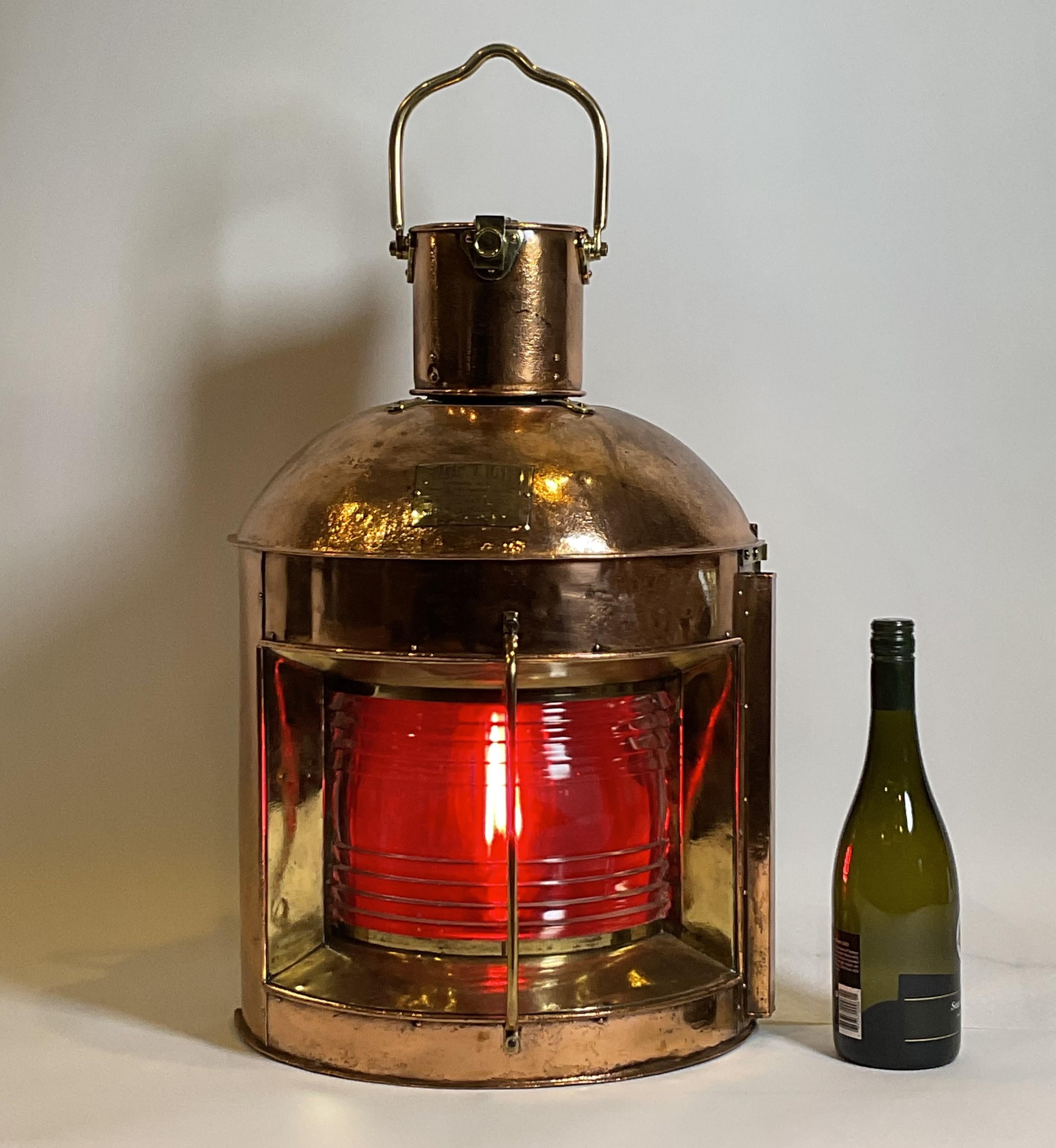Highly polished ships side light port lantern. Copper case with heavy brass handles, hinges, lens bezel and protective bar. Very large in size and quite heavy. Clear fresnel glass lens with removable red filter. Quality nautical antique.

Weight: 21