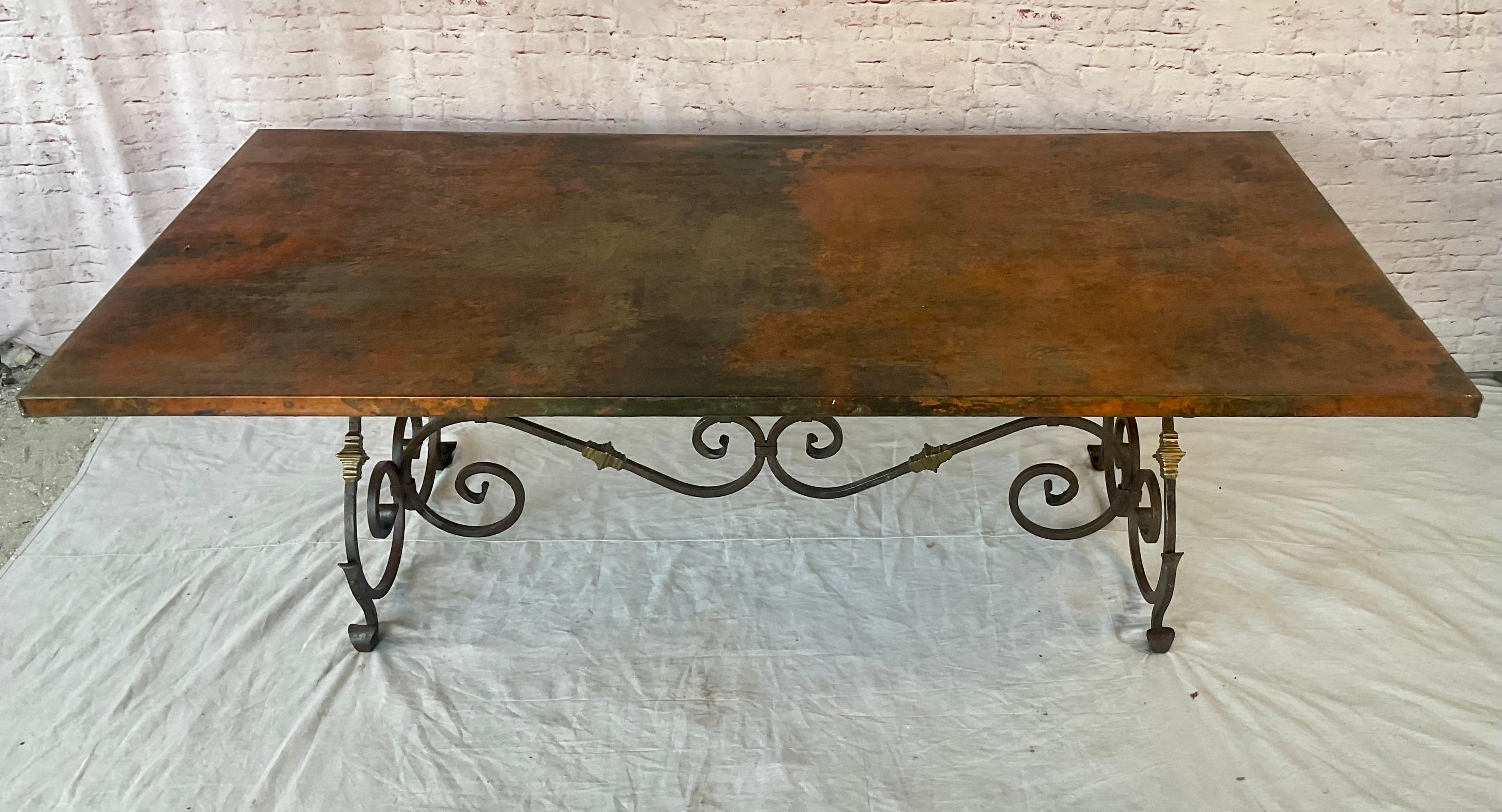Impresionante Mesa de Comedor con Tablero de Cobre y Base de Hierro Forjado a Mano y Latón.
Mesa de comedor con tablero de cobre martillado a mano. La mesa rectangular es grande y presenta una superficie superior revestida de cobre martillado, y
