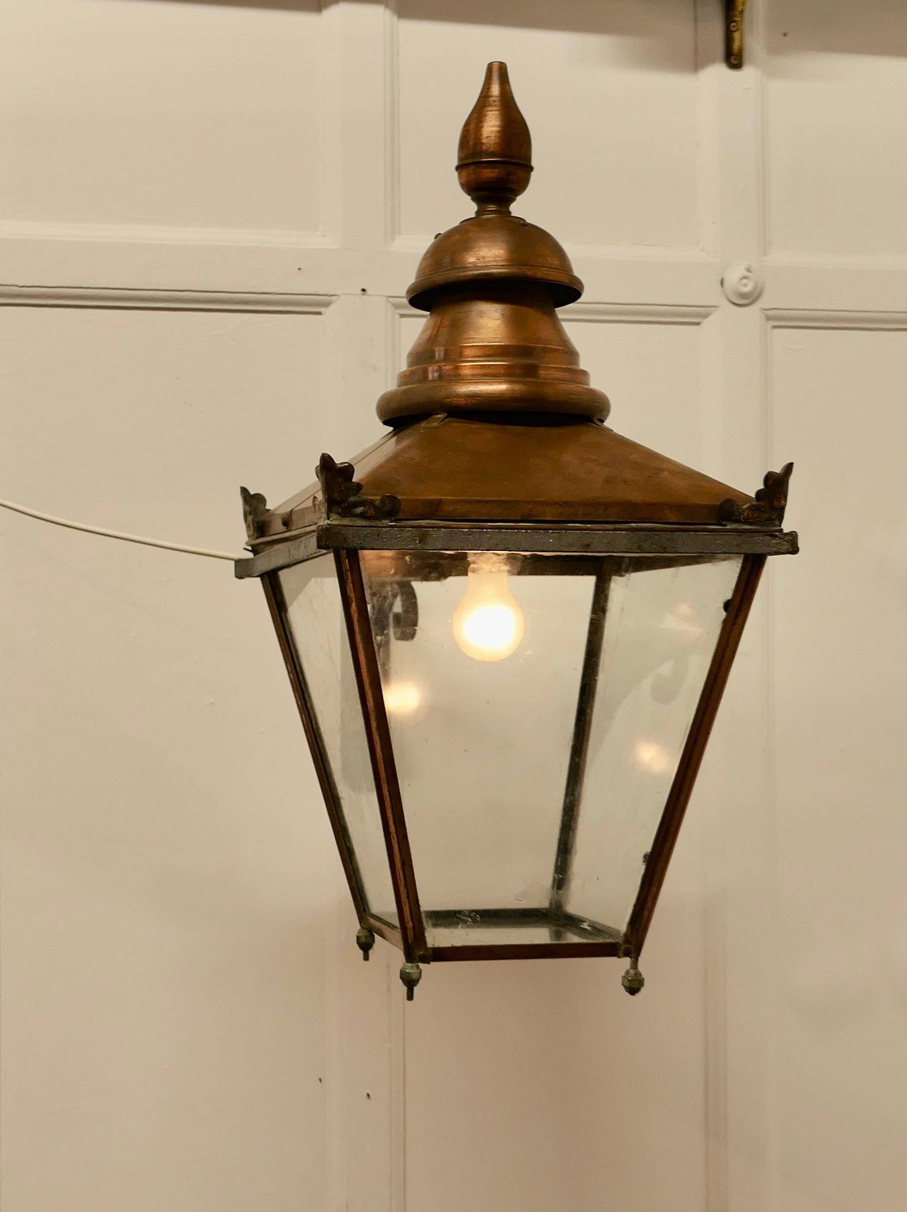 Large Copper Wall Hanging Lantern  

This is a Large Copper street light style Wall Lantern it has a natural oxidised patina, it has glazed sides and at the bottom and it hangs on an iron wall fitting bracket
The copper is old and has a great