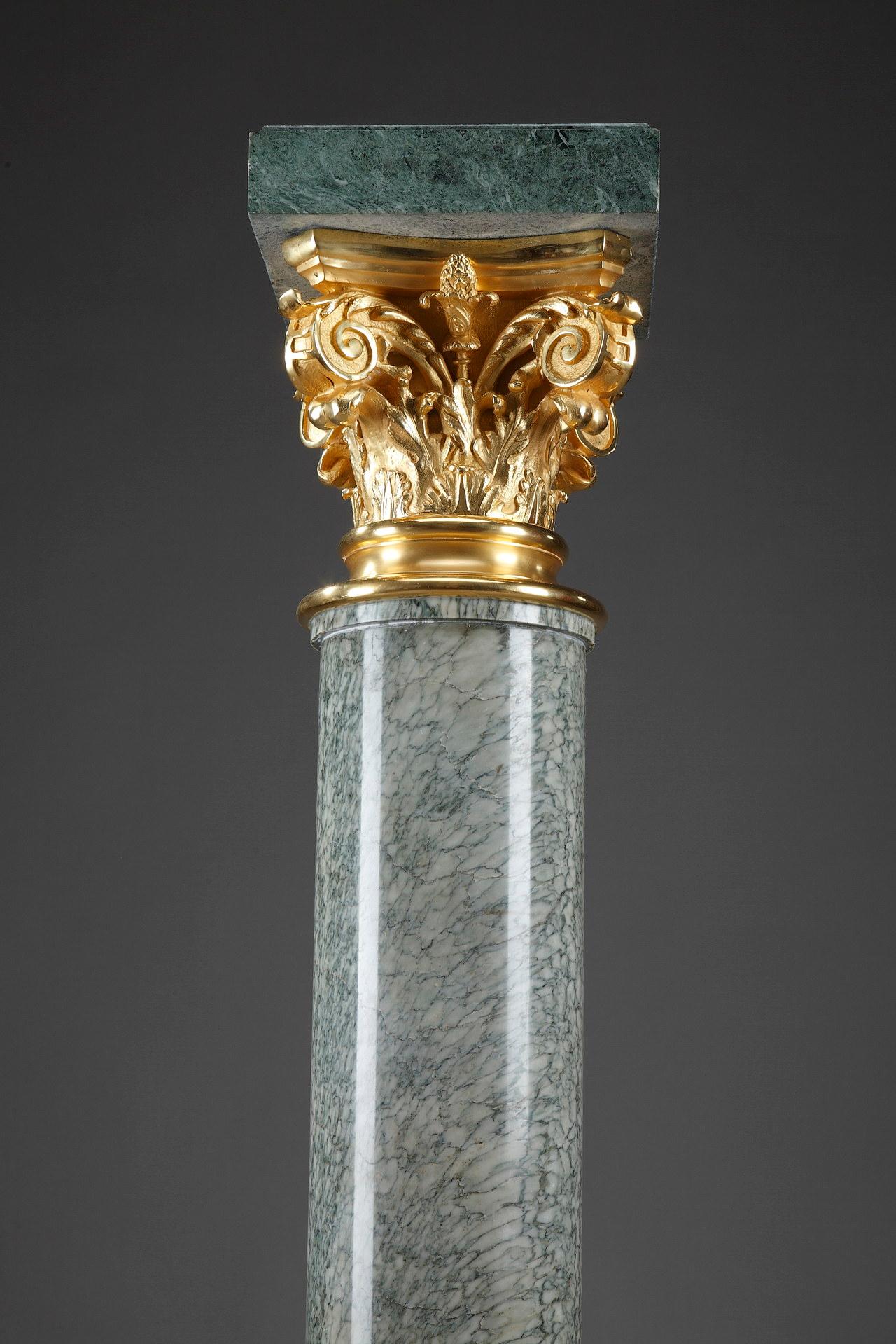 Important sculpture stand in the shape of a Corinthian column. The foliage capital is in gilt bronze. This pedestal rests on a stepped foot decorated with gilded bronzes with leaf crowns and acanthus leaves. The rectangular top is in marble.