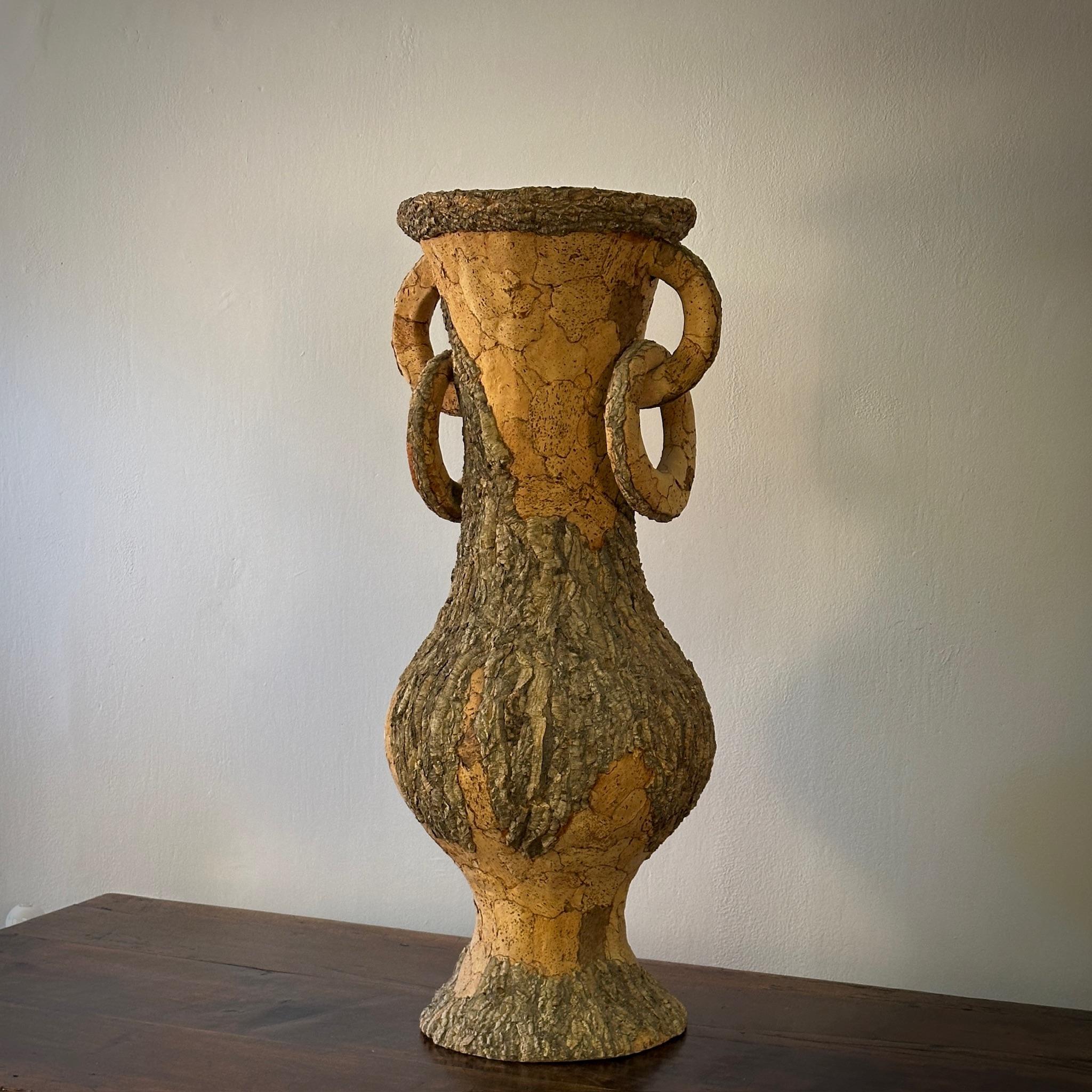 Large early 20th century French urn in cork with a naturalist finish and amphora shape. Featuring two handles with ring accoutrements, this sculptural vessel adds an organic yet stately touch to any room.

France, circa 1900

Dimensions: 14.5W x