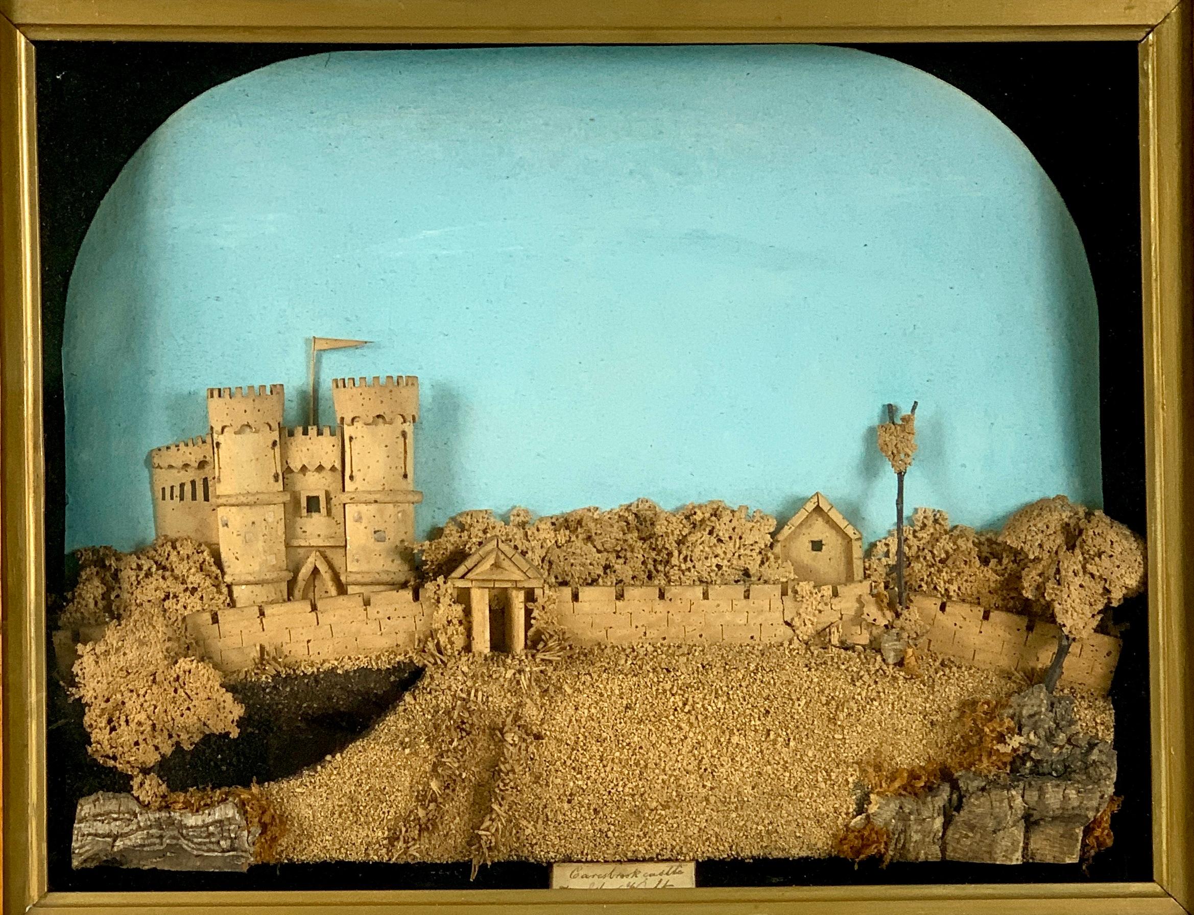  This hand-crafted cork work shows a romantic scene of Carisbrooke Castle on the Isle of Wight in a charming diorama. 
The castle is perched atop a mountain complete with a long protective wall and an open gate. 
The artist's intricate cutting and