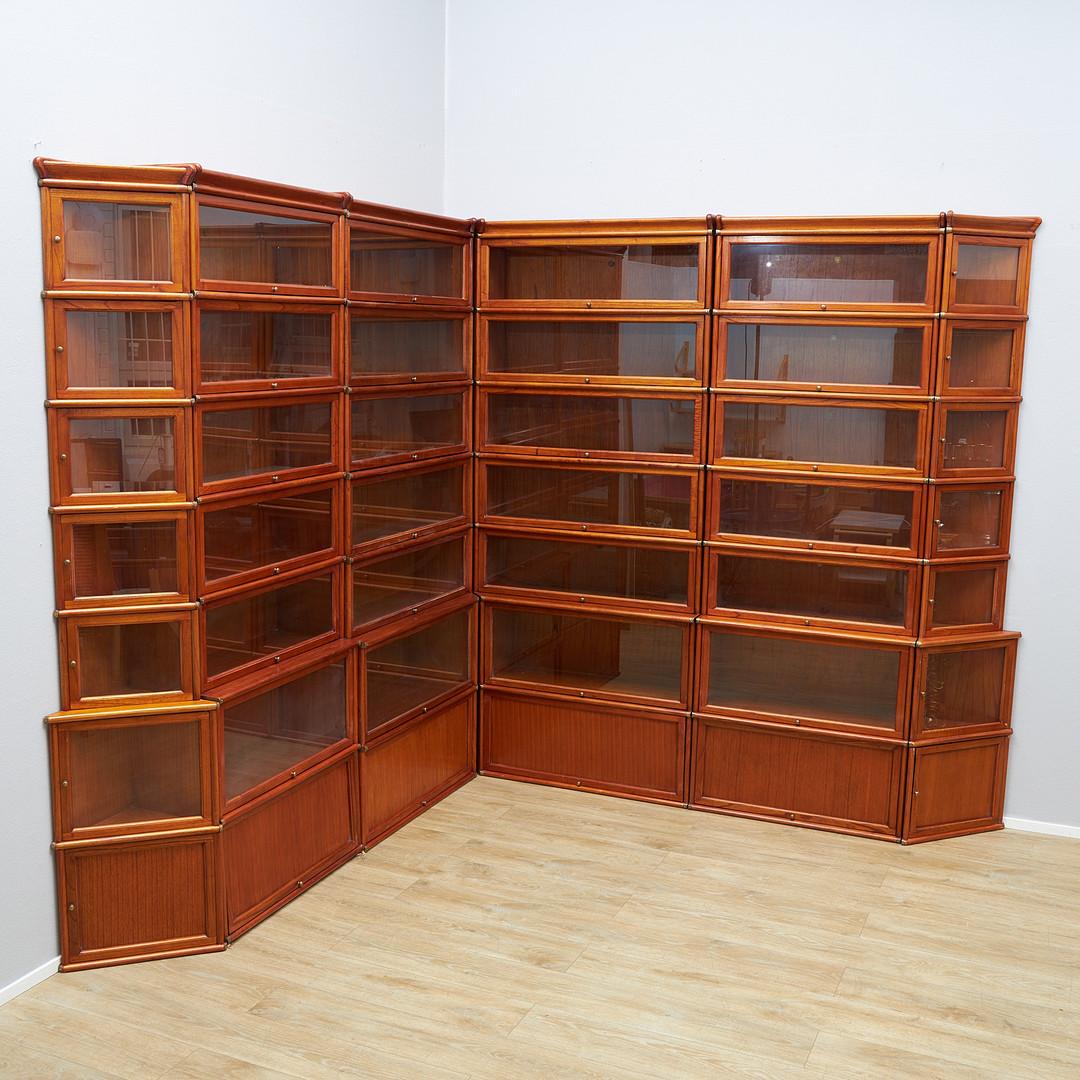 Rara libreria barrister in un grande set angolare. Il mobile presenta 6 colonne di librerie impilabili di diverse dimensioni che permettono di riporre libri o oggetti di diverse altezze e dimensioni. È realizzato in legno massiccio, intorno alla