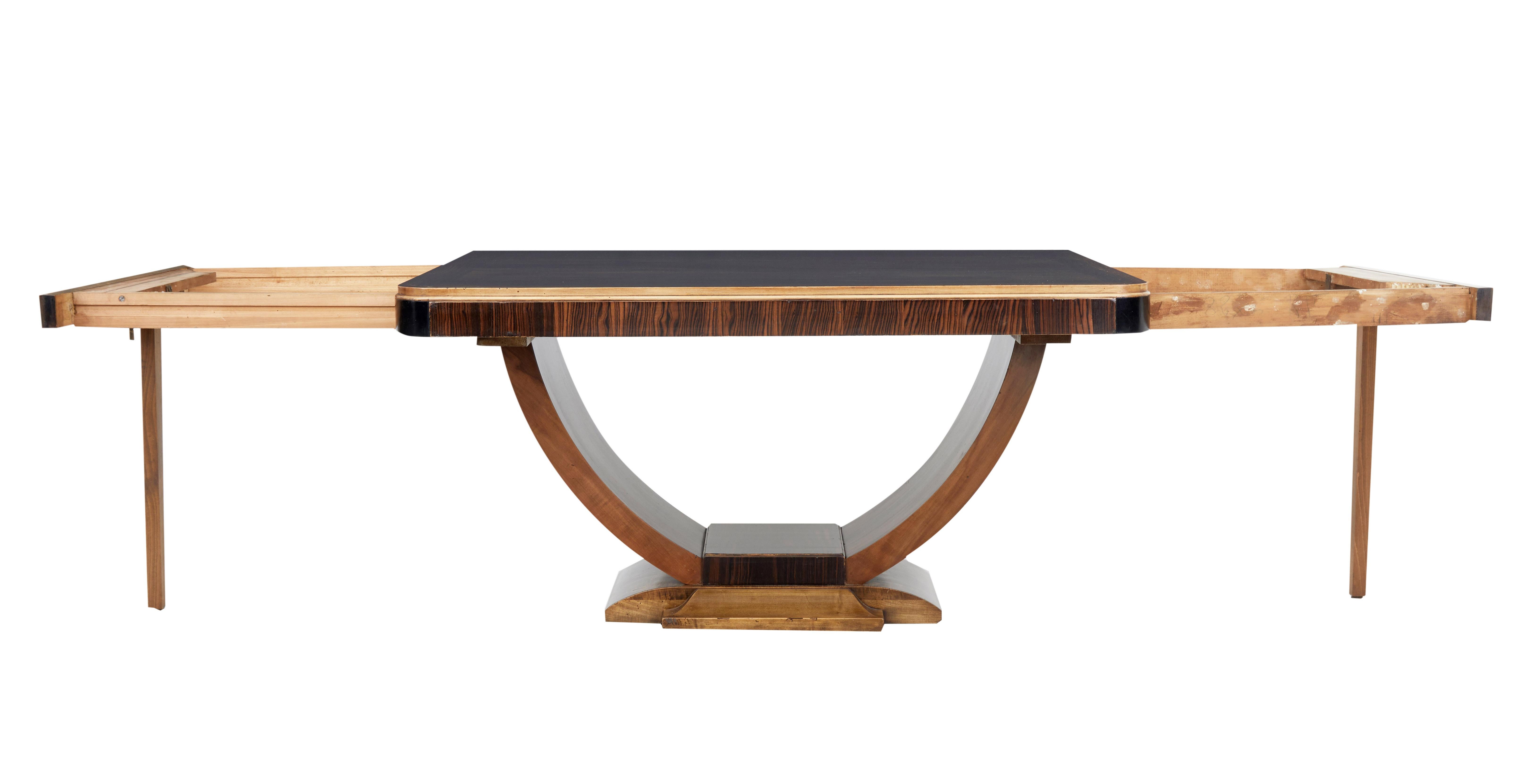 Stunning Art Deco period center table, circa 1930.

Formerly and extending table, now lacking leaves but would be possible to have leaves made.

Striking Coromandel veneered top surface, with contrasting birch and ebonized edging. Standing on a
