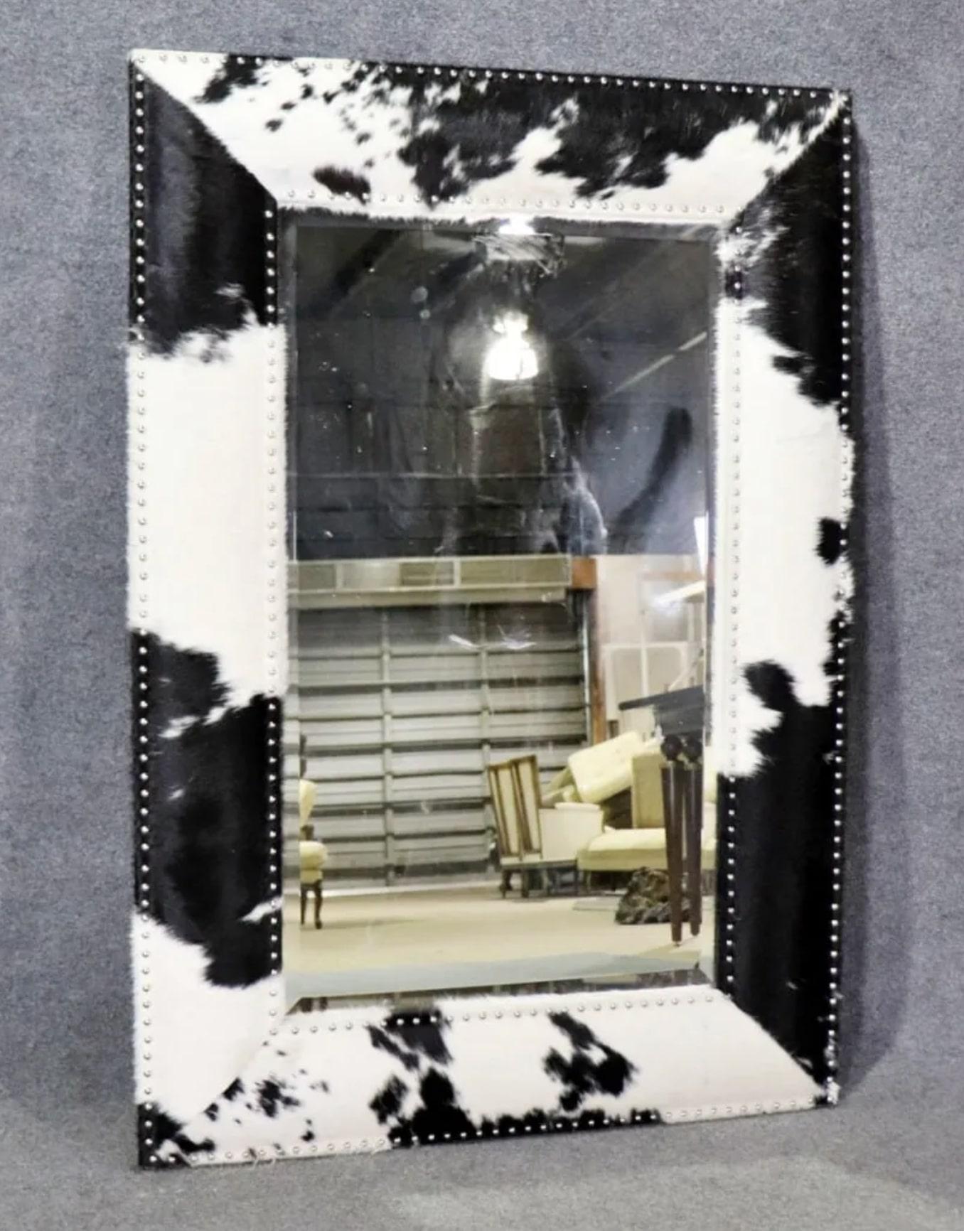 Black and white hide frame mirror with exposed nail trim. 
Please confirm location NY or NJ