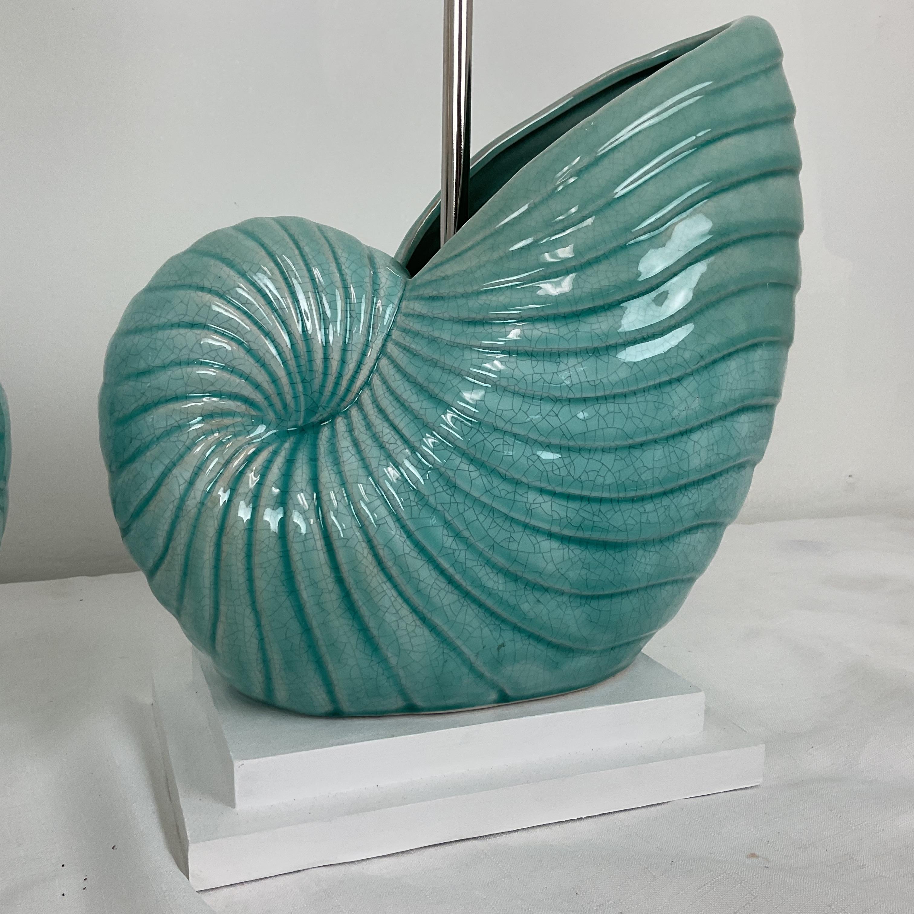 Gorgeous modeled turquoise crackled glaze finish coastal style with tiered white wood bases. Perfect for an upscale coastal living space. Lamps are opposing pair.