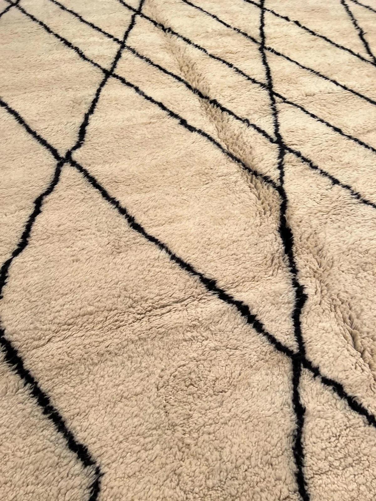 This large cream neutral handwoven Beni Ourain rug was made by hand by skilled artisans in the Atlas Mountains using the highest quality Moroccan wool. It is impressive in both size and design, and is the perfect luxury statement piece for any room.