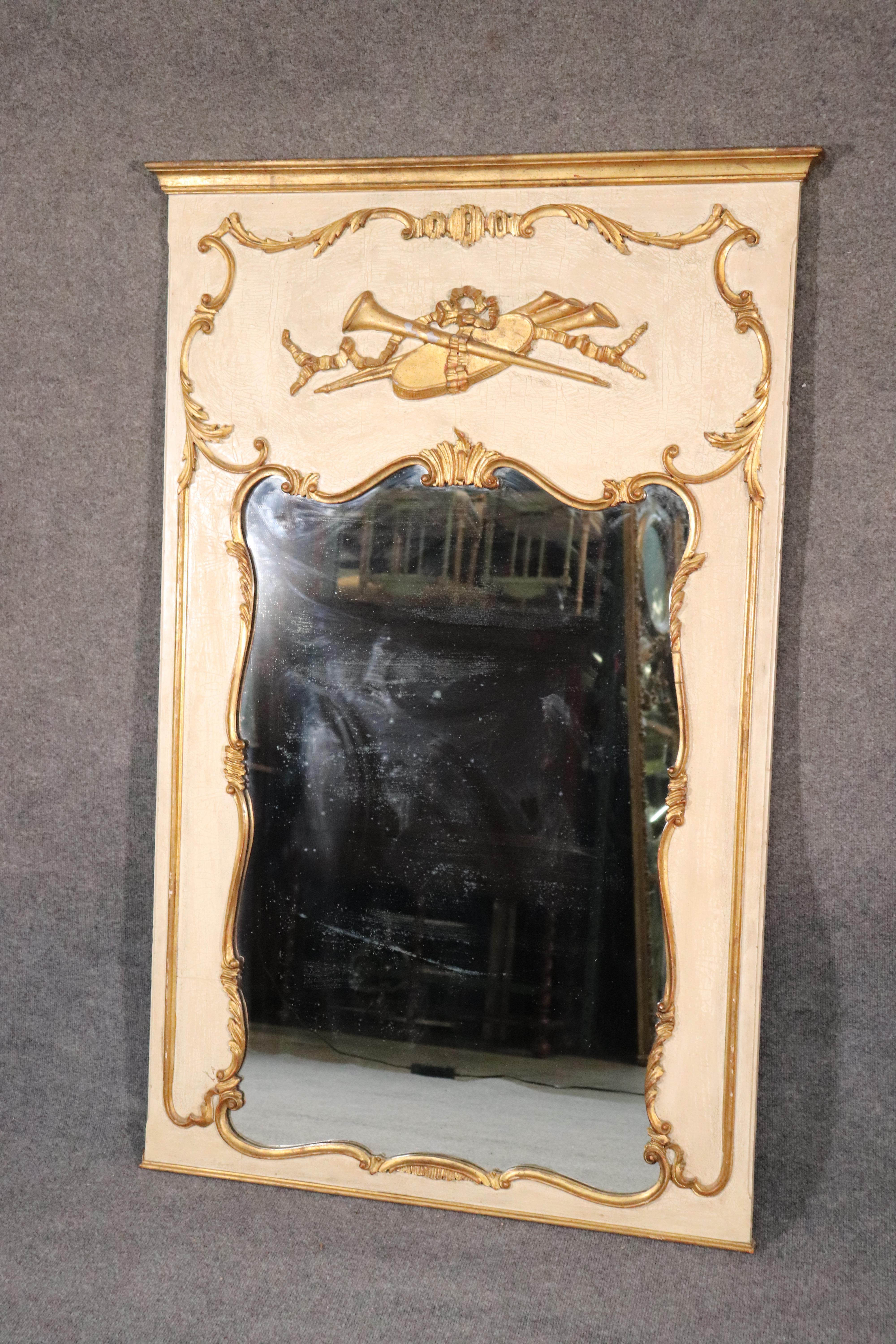 This is a gorgeous Italian made French Louis XV crème painted and gold leaf mirror. The mirror is in good original condition. The mirror measures 59 tall x 38 wide x 2 inches deep.
