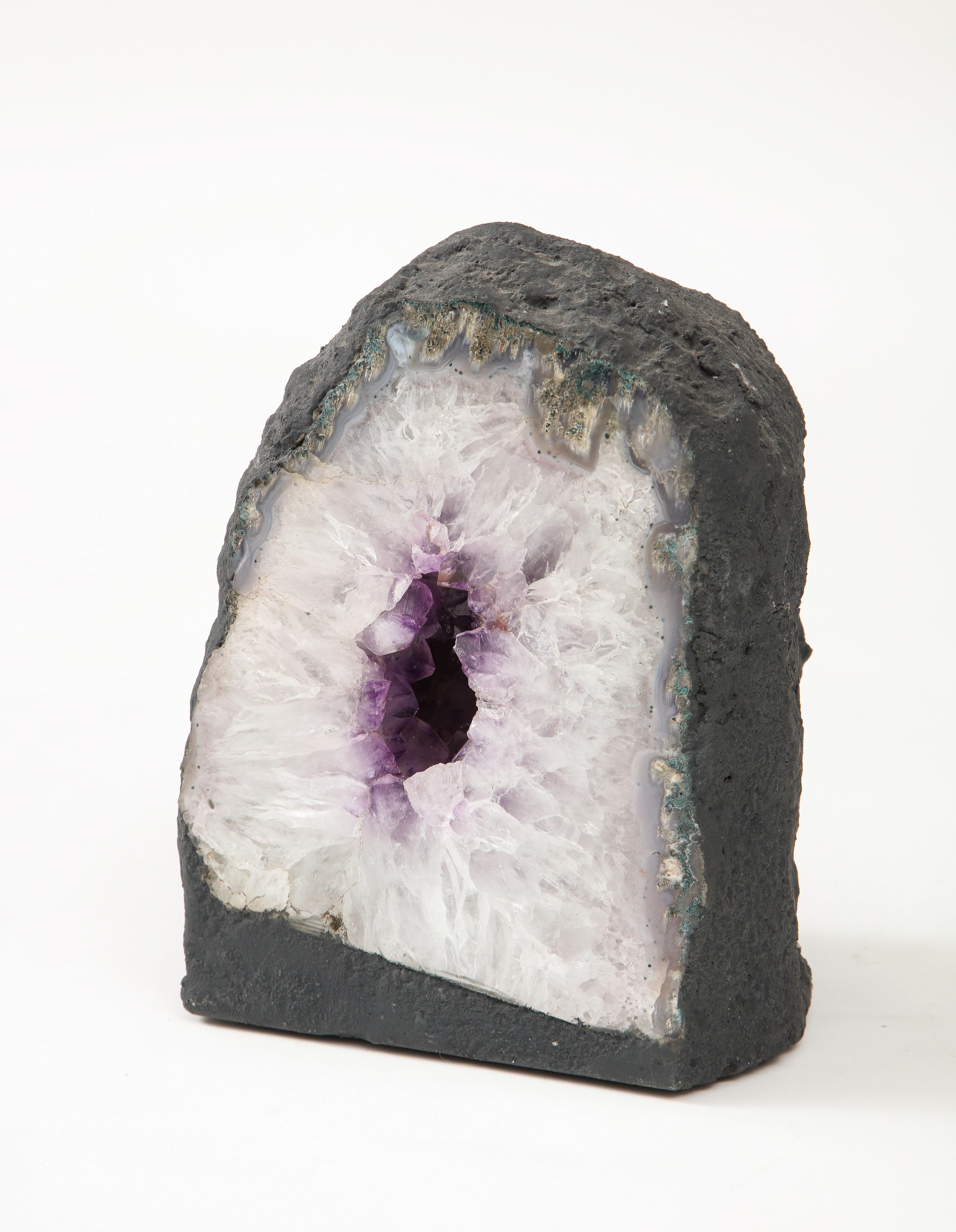 A large geode crystal specimen featuring an amethyst center.