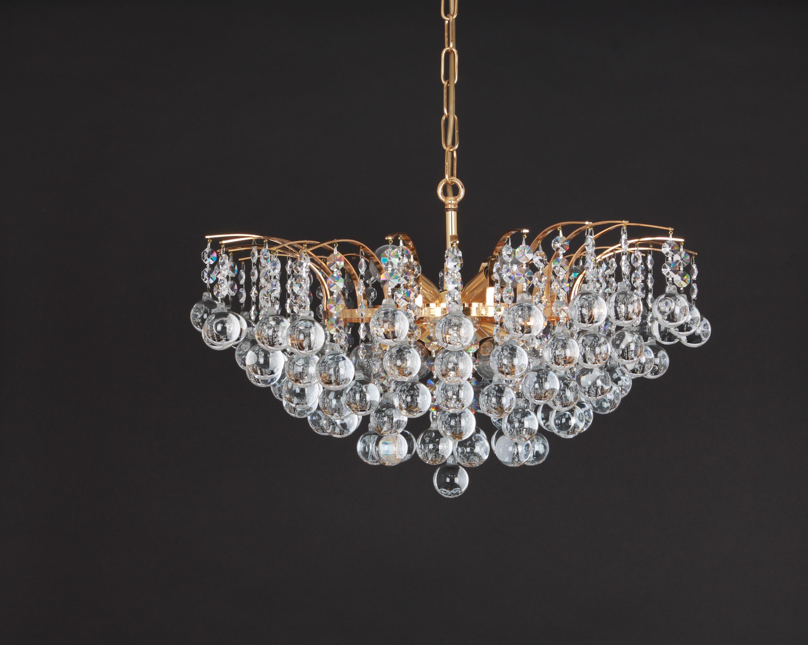 A stunning chandelier by Christoph Palme, Germany, manufactured in the 1970s. It’s composed of too many crystal glass pieces (over 90) on a gilded brass frame.
High quality of materials.

The chandelier needs 10 small Edison balls (E-14) up to 40