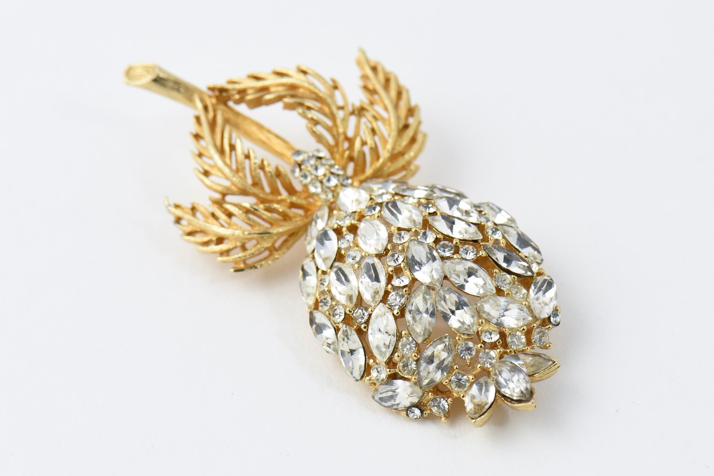 Impressive three dimensional large crystal flower brooch with a gold tone stem and leaves.