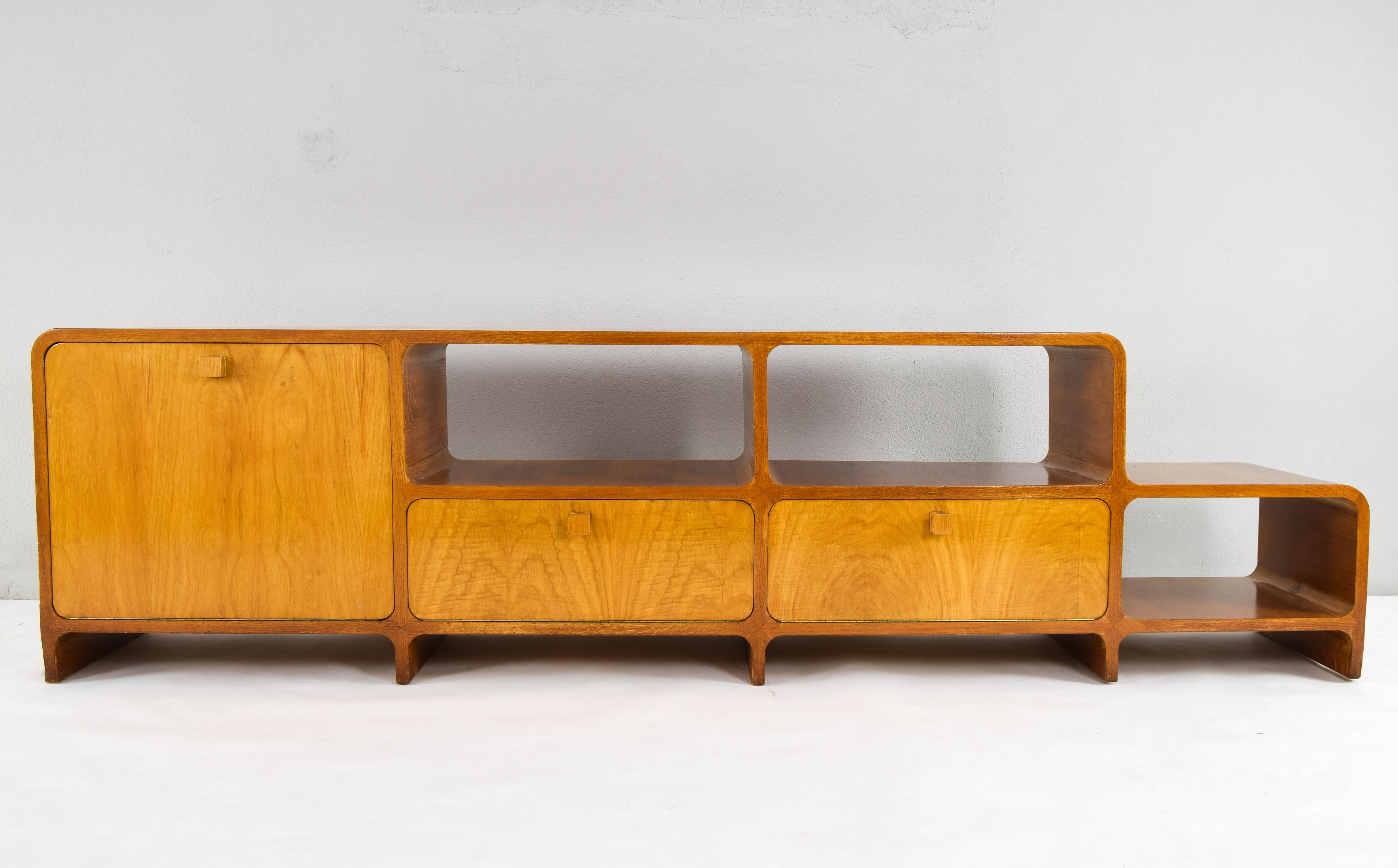 Exceptional Mid-Century Modern veneered teak room divider from Denmark and manufactured in the 1960s.
Its handles are square and made of wood.
Large and very robust double-sided Bauhaus sideboard. With all its curved angles and different levels of
