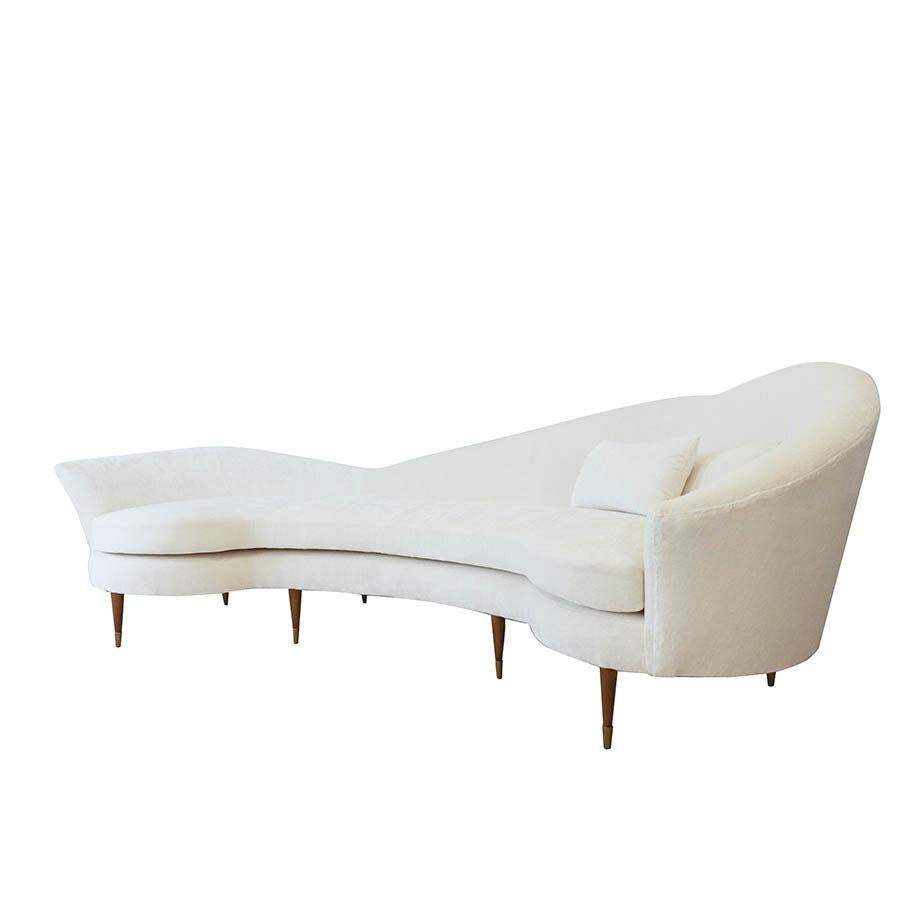 This large curved sofa was inspired by midcentury Italian design. Upholstered in white crushed velvet. The sofa features a single cushion with foam, dacron, and down. Its tight back is soft, curvy and accommodating for lounging. The legs are Art
