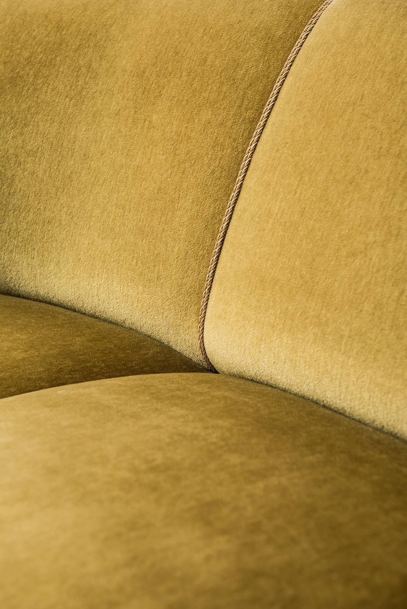 Large curved sofa in green or yellow velvet. Produced in Denmark.