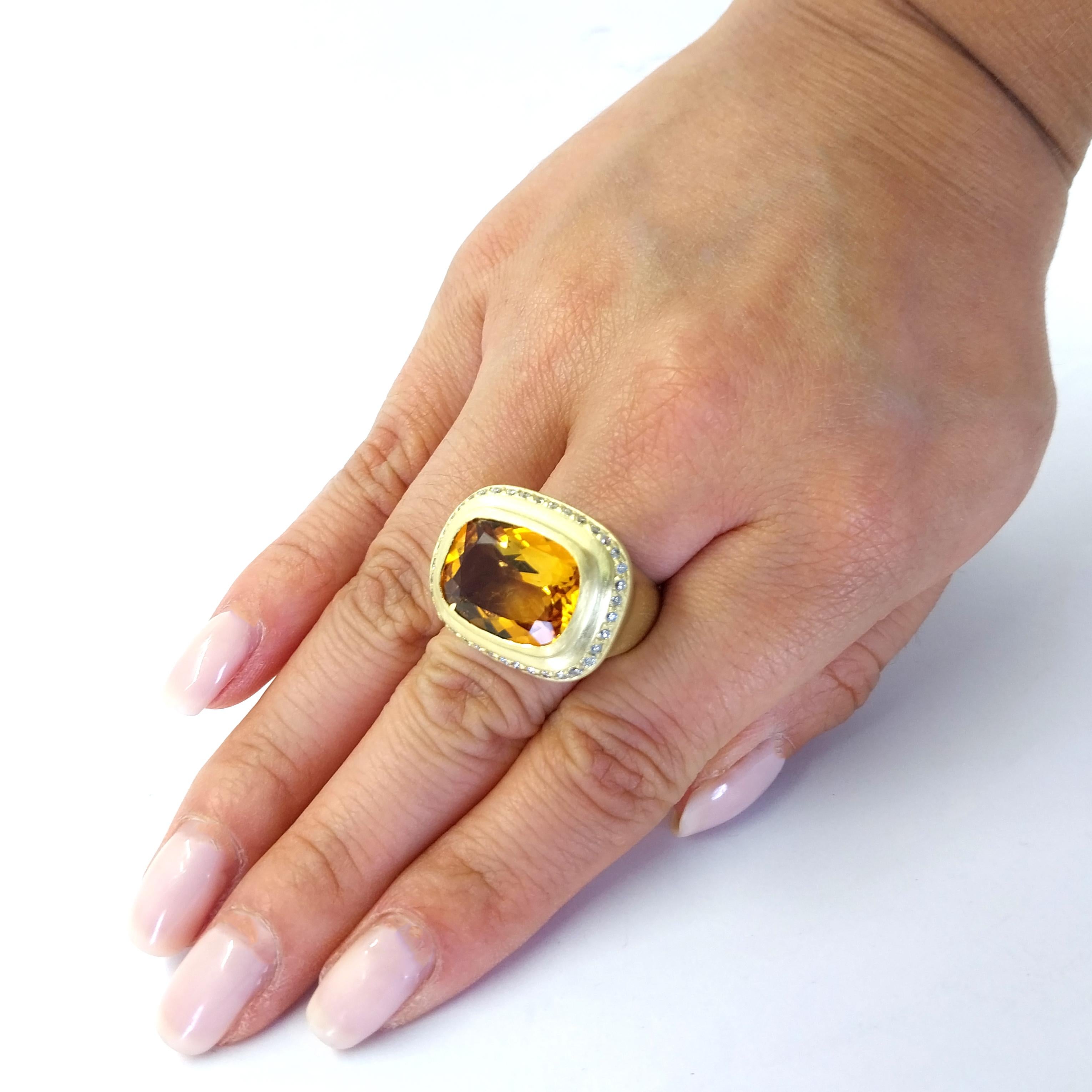 Luxurious 18 Karat Yellow Gold Brushed Finish Cocktail Ring Featuring A Bezel-set Cushion Cut Citrine Weighing Approximately 8 Carats Surrounded by 39 Round Brilliant Cut Diamonds of SI Clarity and H Color Totaling 0.39 Carats. Finger Size 7.5.
