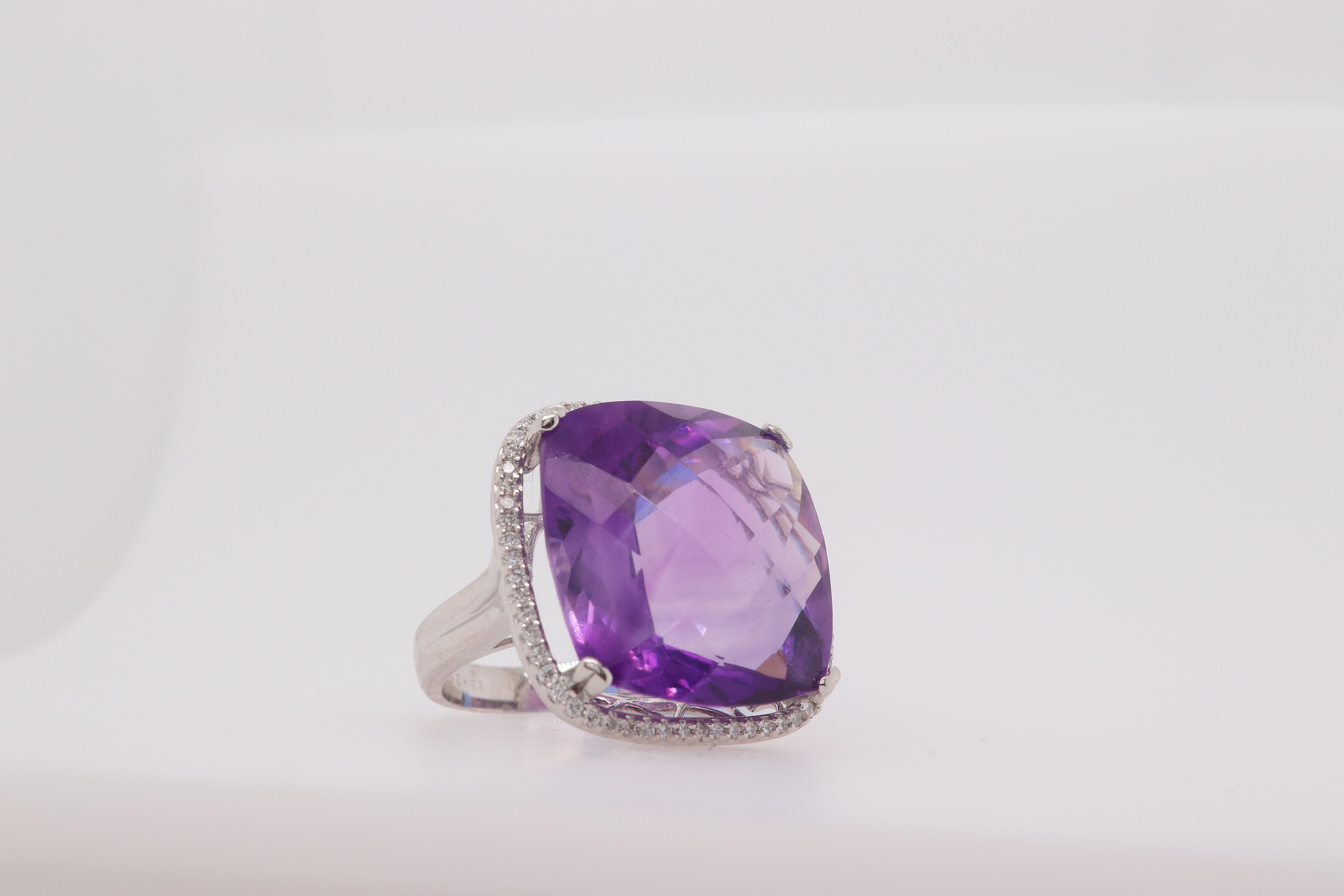 A uniquely large purple amethyst cocktail ring.

Material: 14k White Gold 
Stone Details: 1 Cushion Amethyst at 23.25 Carats Measuring at 19mm
Mounting Stone Details: 60 Brilliant Round Diamonds at 0.38 Carats
Ring Size: 6.5. Alberto offers