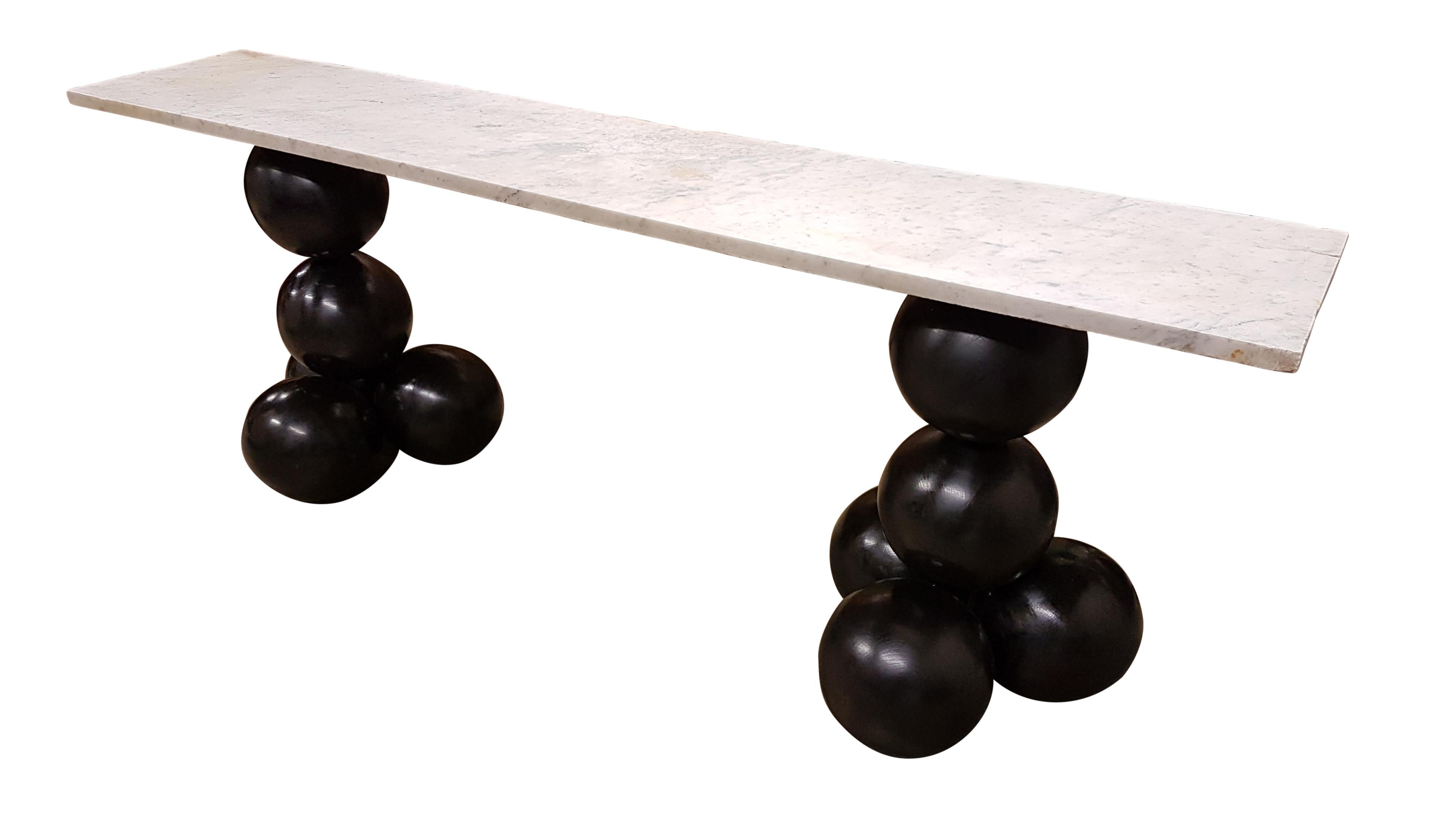 A beautiful and decorative custom console table. The bases are bulbous constructed from 10 25cm diameter wooden balls all jointed together and then ebonized.
We sourced a 25mm thick antique Carrara marble slab that has a very nice weathered finish,