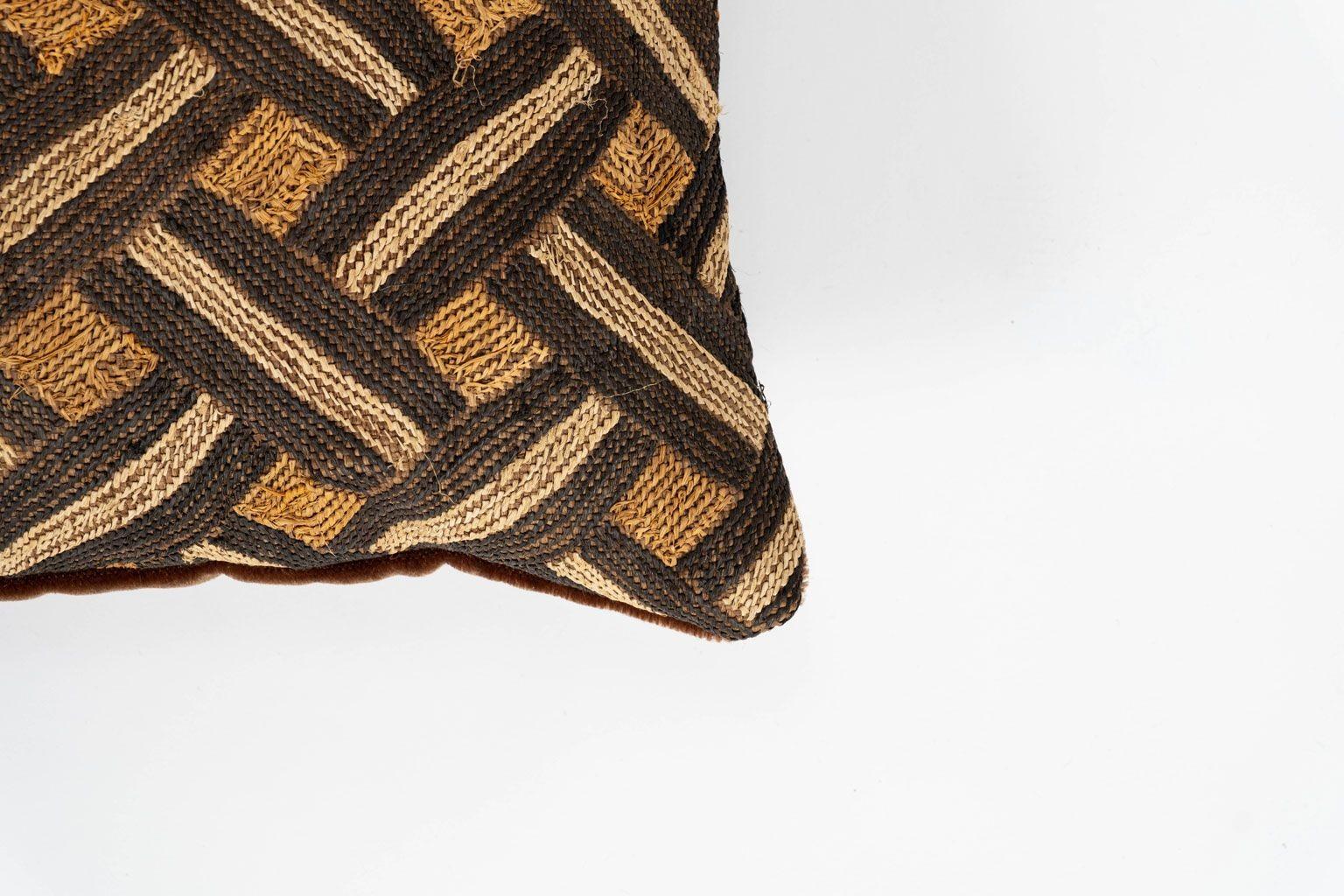 Large custom cushion from vintage African Kuba cloth. Hand-dyed raphia palm handwoven in an interlocking pattern. Backed by brown velvet. Includes zip fastener and feather insert.