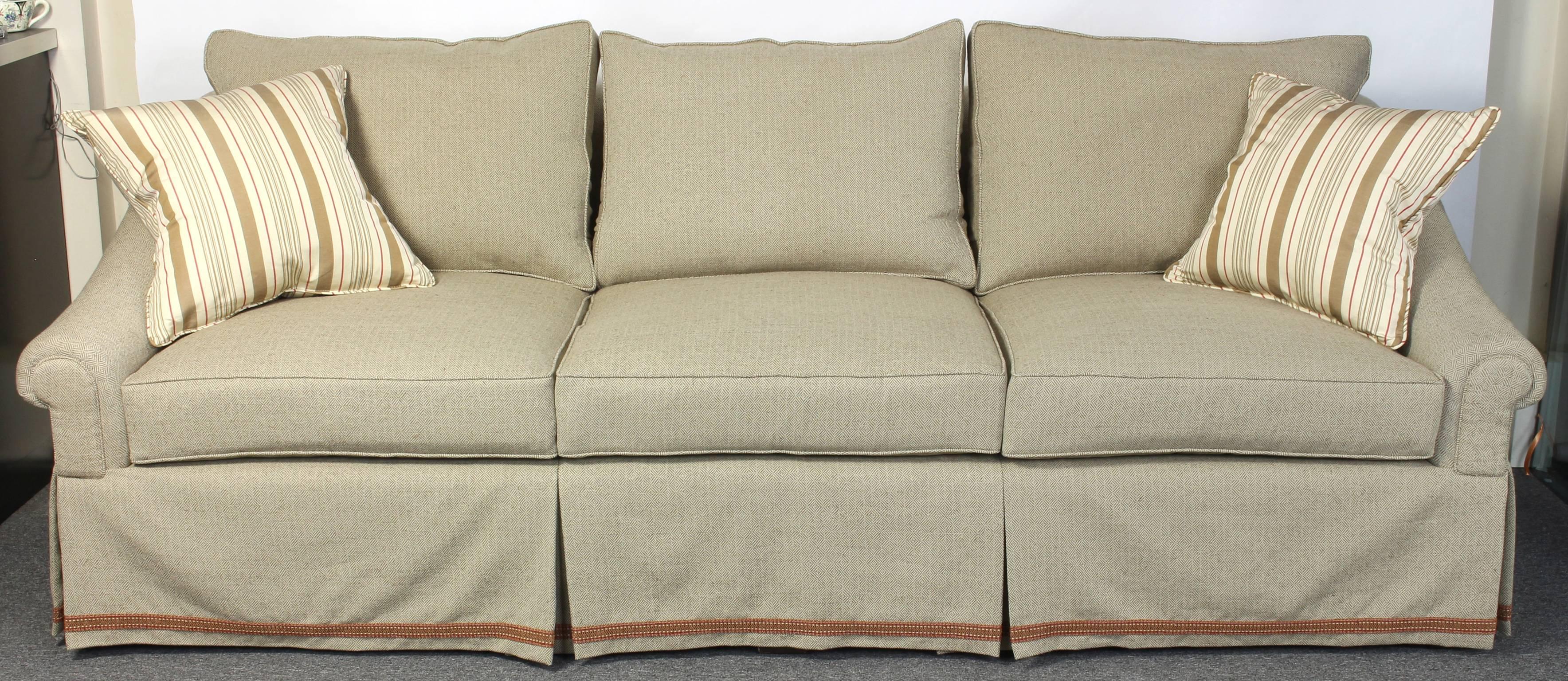 A large custom designed and fabricated three-seater sofa newly upholstered in a neutral woven cotton fabric with three optional back cushions and six additional 20