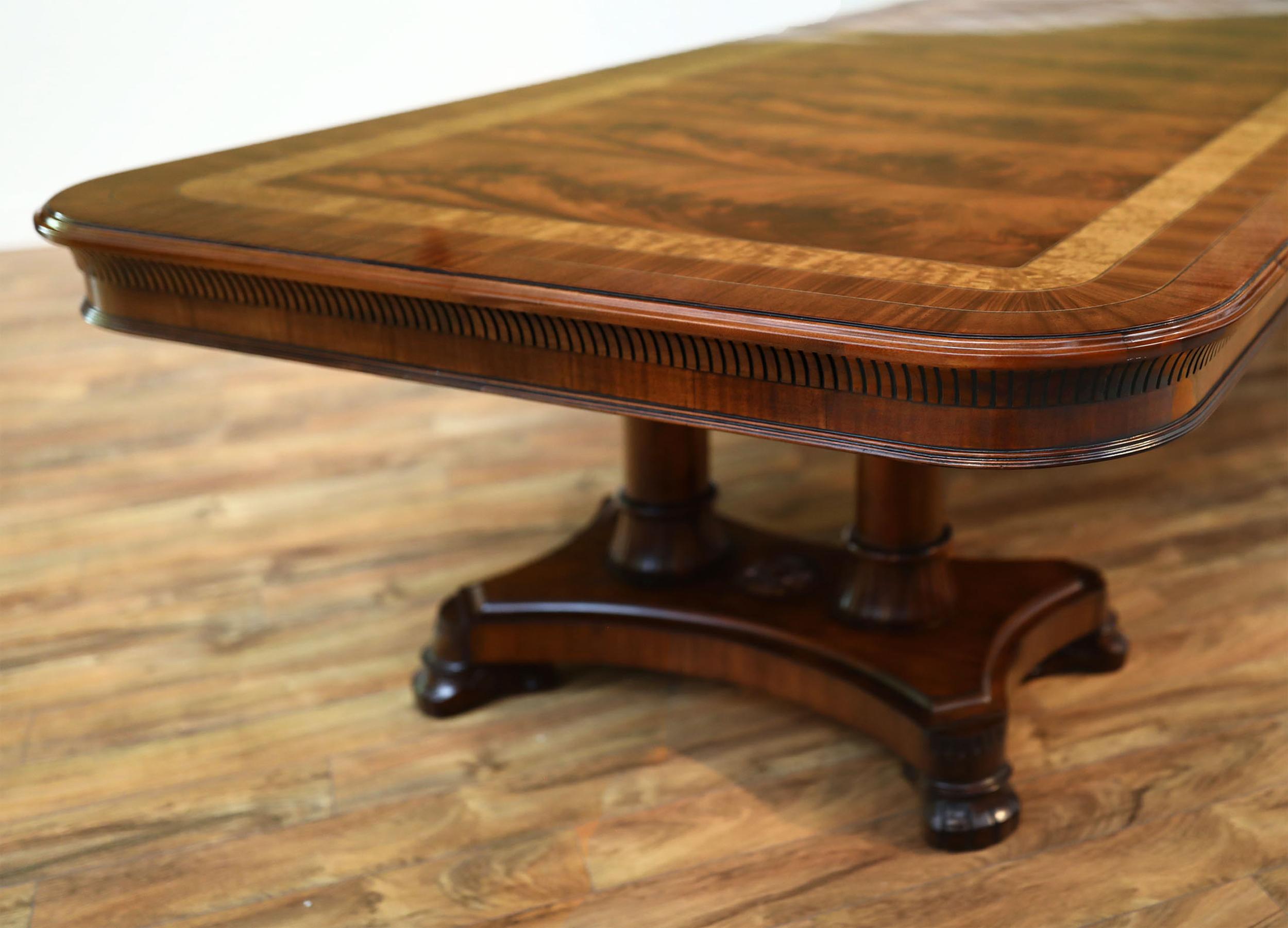 This is made-to-order large mahogany dining table made in the Leighton Hall shop. This is one of our flagship tables and is known as the King Demure dining table. It has a transitional design inspired by the original 18th century Regency style