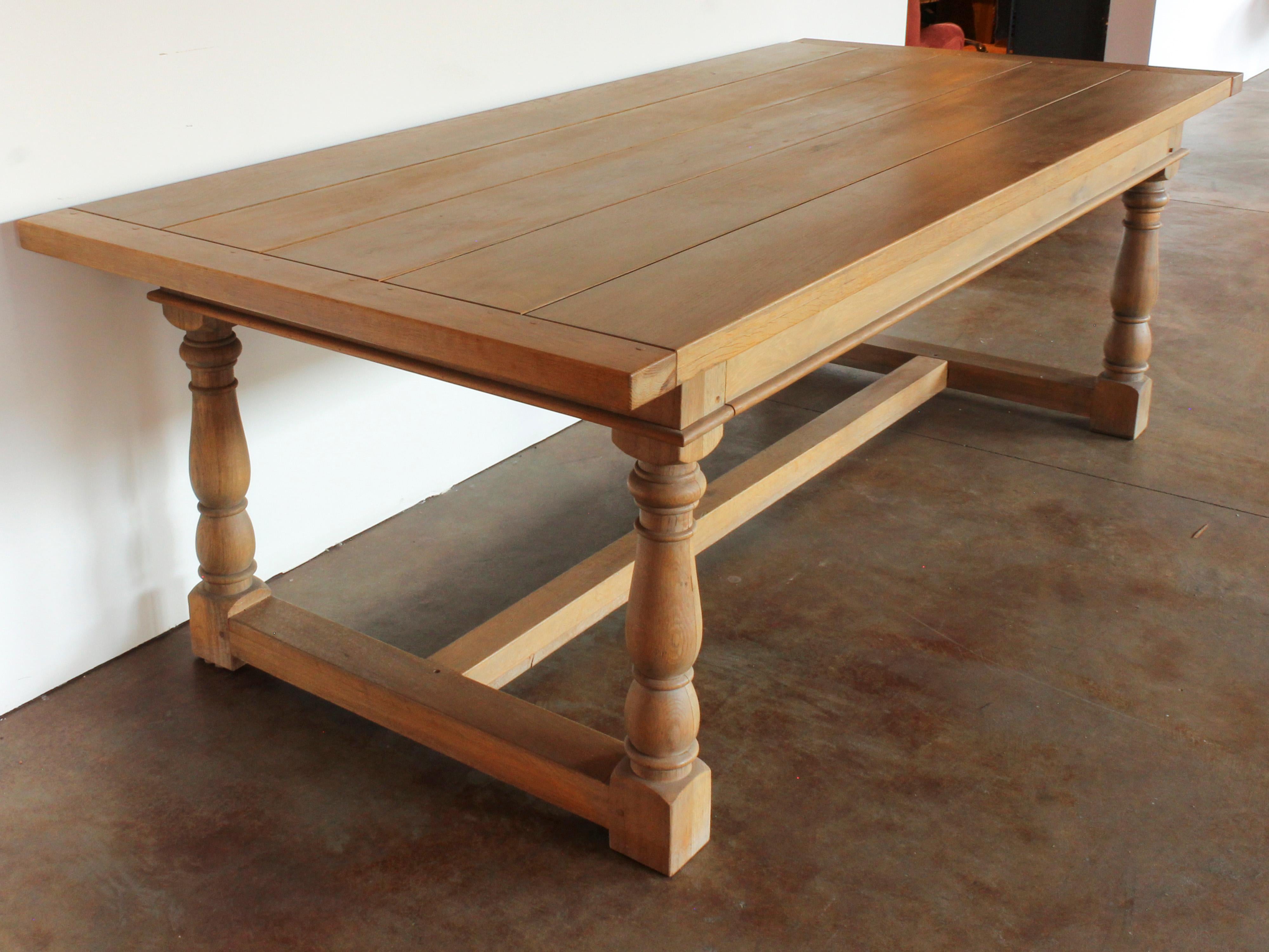 Large custom oak plank-top dining table with carved spindle legs and stretchers. Custom made by Old Plank Road in Chicago exclusively for Nate Berkus Associates. Two tables available.