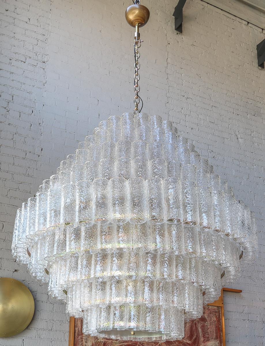 Grand lustre personnalisé composé de neuf étages de tubes en verre de Murano texturé transparent, avec une chaîne et un baldaquin en laiton. Peut être réalisé en différentes tailles et finitions. 

Le baldaquin et la chaîne ajoutent 24