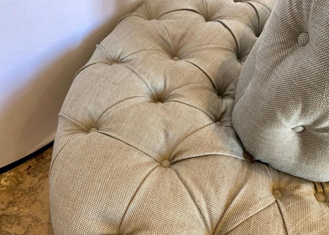 Tastefully upholstered in a vintage Herman Miller fabric, this large oval shaped banquette is noting short of gorgeous. The color of the fabric is best described as a gray seafoam. Measures five feet by four feet and sits on bun feet. The center