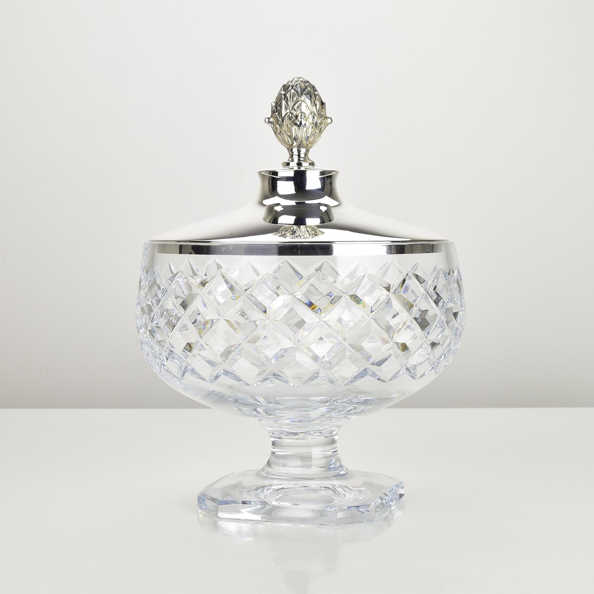 Elegante bombonera o cuenco vintage con tapa, de cristal tallado transparente, con un llamativo dibujo de rombos y una reluciente tapa de plata de ley .925. La tapa plateada está adornada con un remate en forma de piña finamente detallado, que añade
