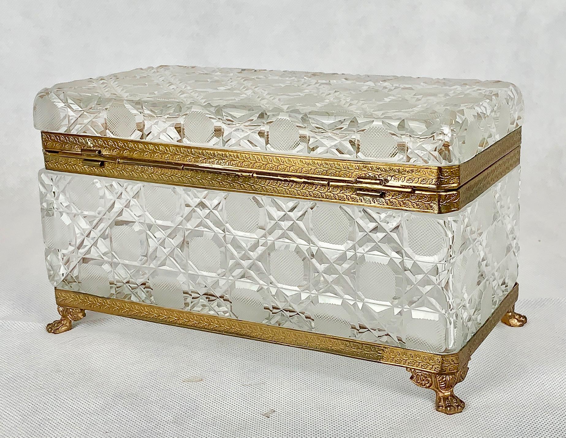 Large cane cut or hobnail crystal box with gilt frame. The frame has a pattern of branches and leaves. The feet are lion's paws and the bottom is star cut. This box is in crystal clear condition.
Measures: 10