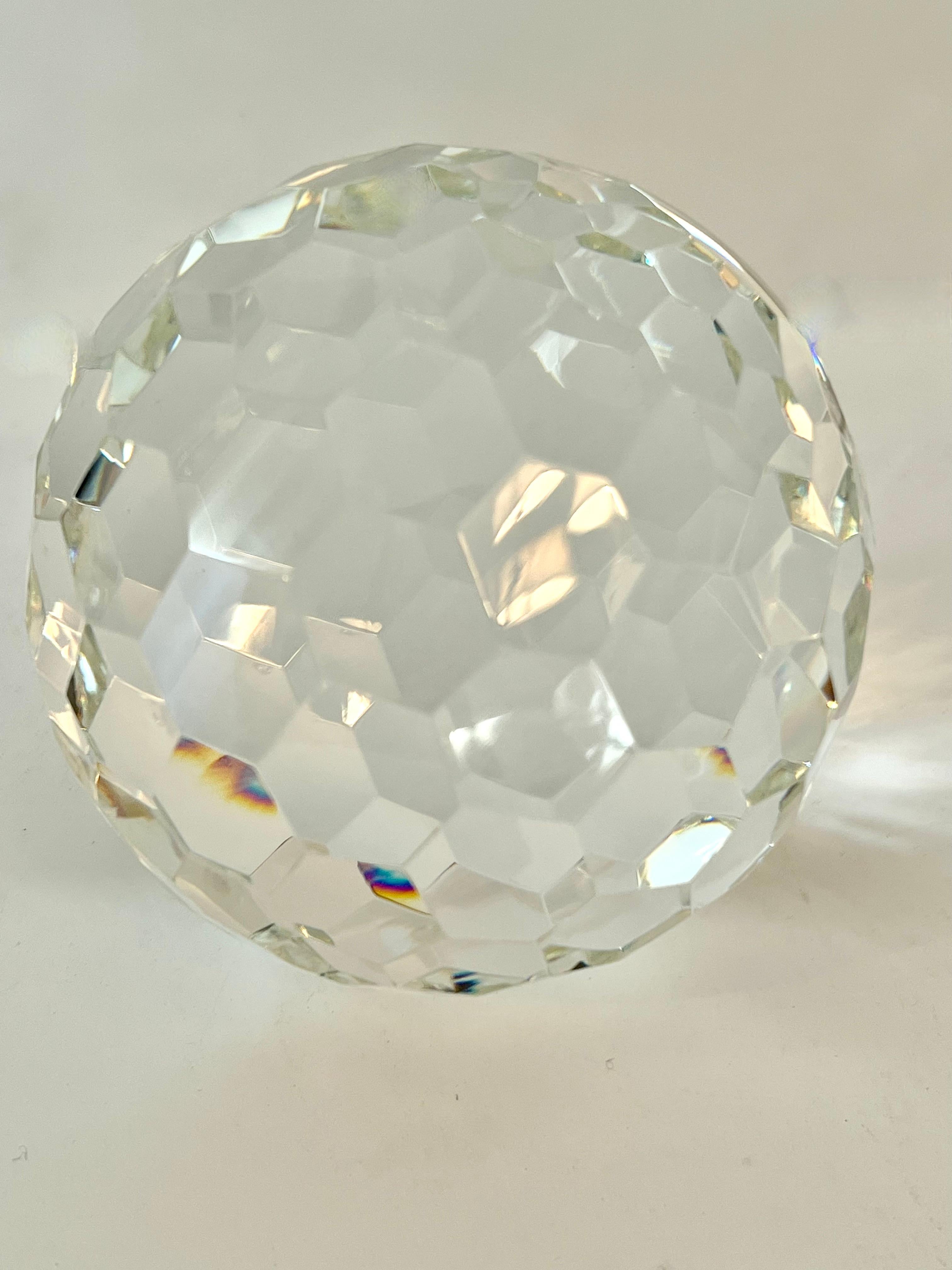 A large and weighty crystal ball - cut crystal is brilliantly multi-faceted, 

The piece reflects light from every angle - also works well as a bookend or sit alone sculpture.  Due to it's similarity to a golf ball this would be a great addition to