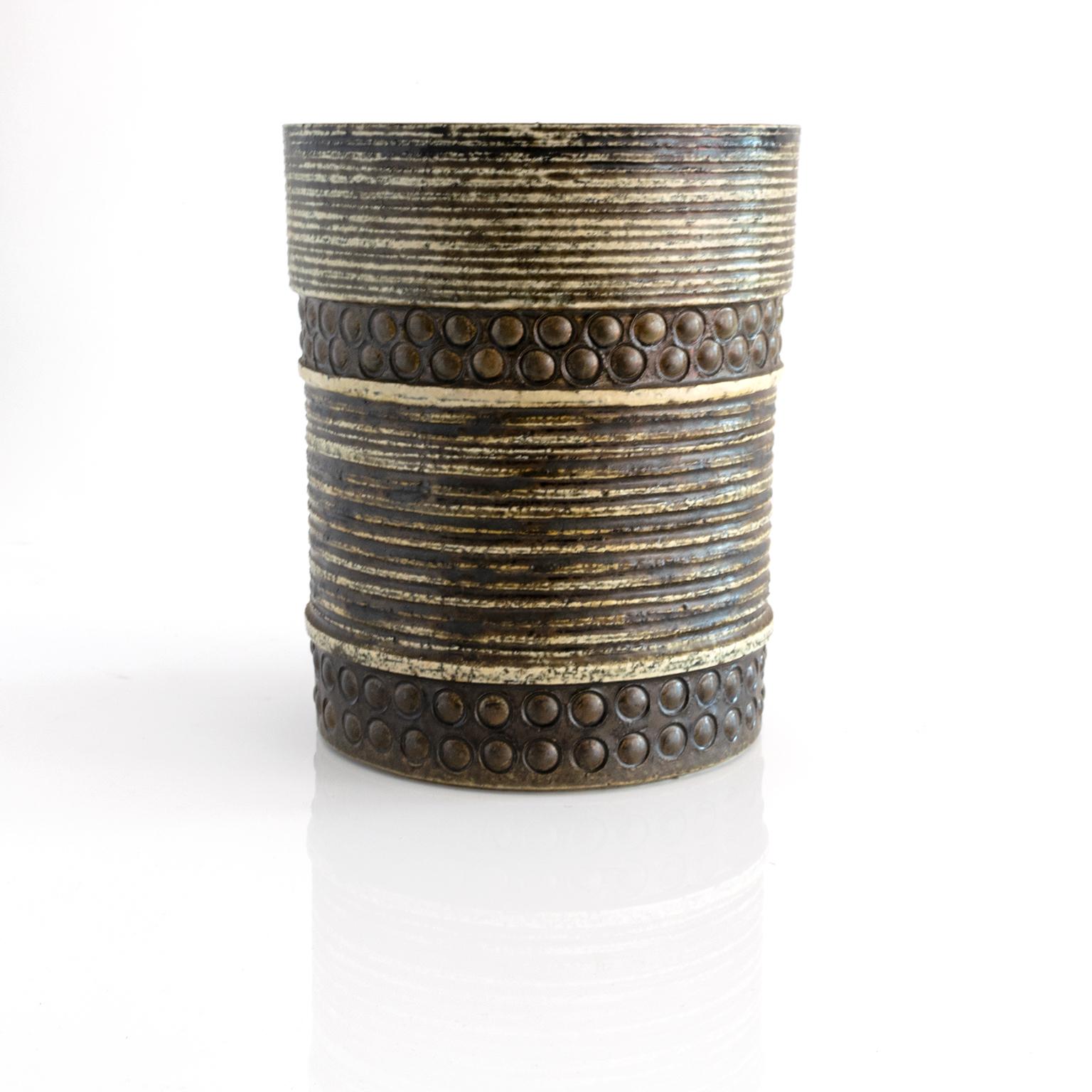 A large cylinder shaped vase by Britt-Louise Sundell for Gustavsberg, circa 1960. The vase has a highly textured surface (chamotte clay) with impressed circles and horizontal lines.

Measures: Height 9.5