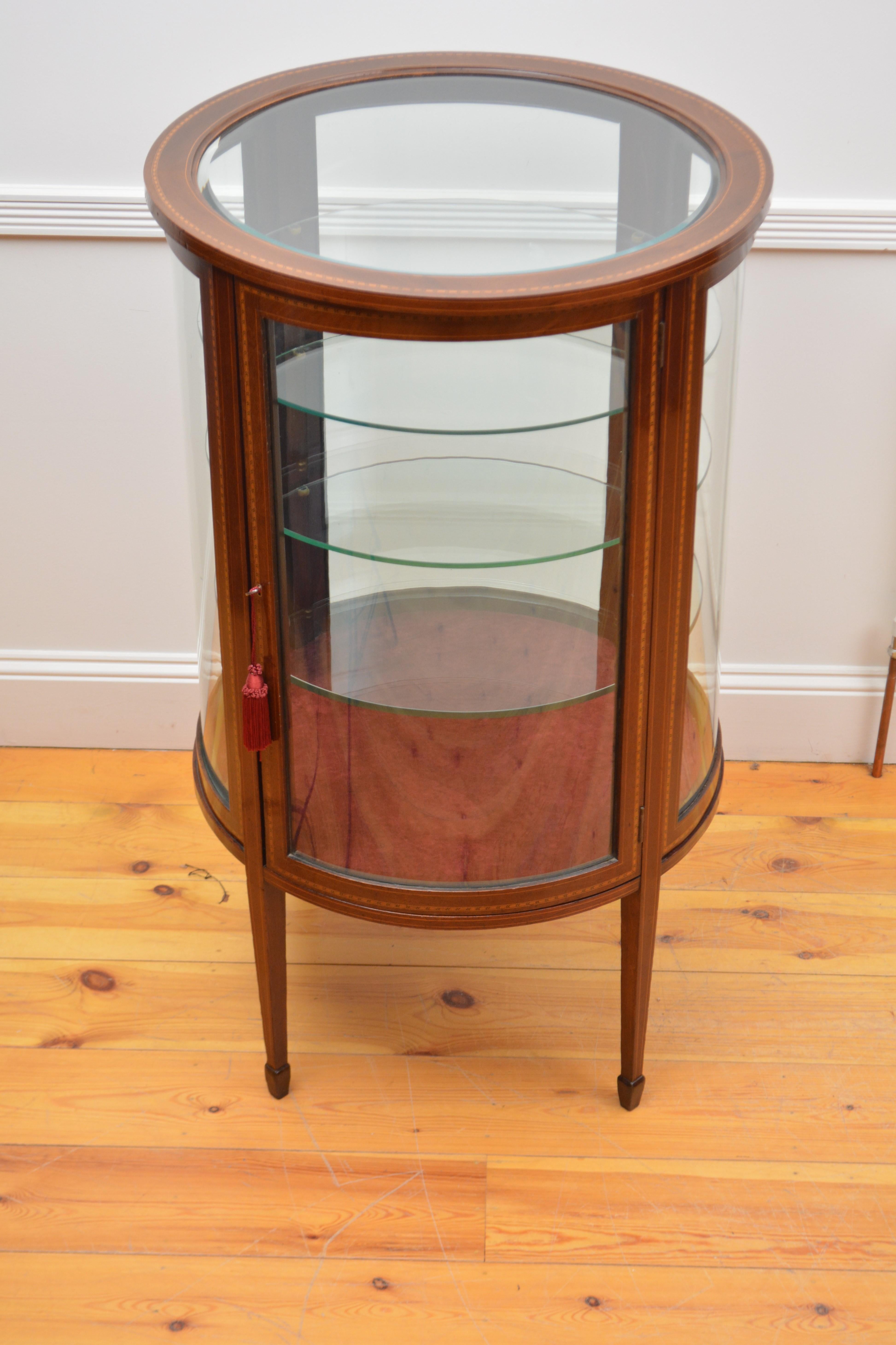 Sn4427  Rare and very unusual Edwardian cylindrical display cabinet / vitrine, having original bevelled edge glass to inlaid top, inlaid door fitted with original working lock and a key enclosing three glass shelves and newly lined interior, all