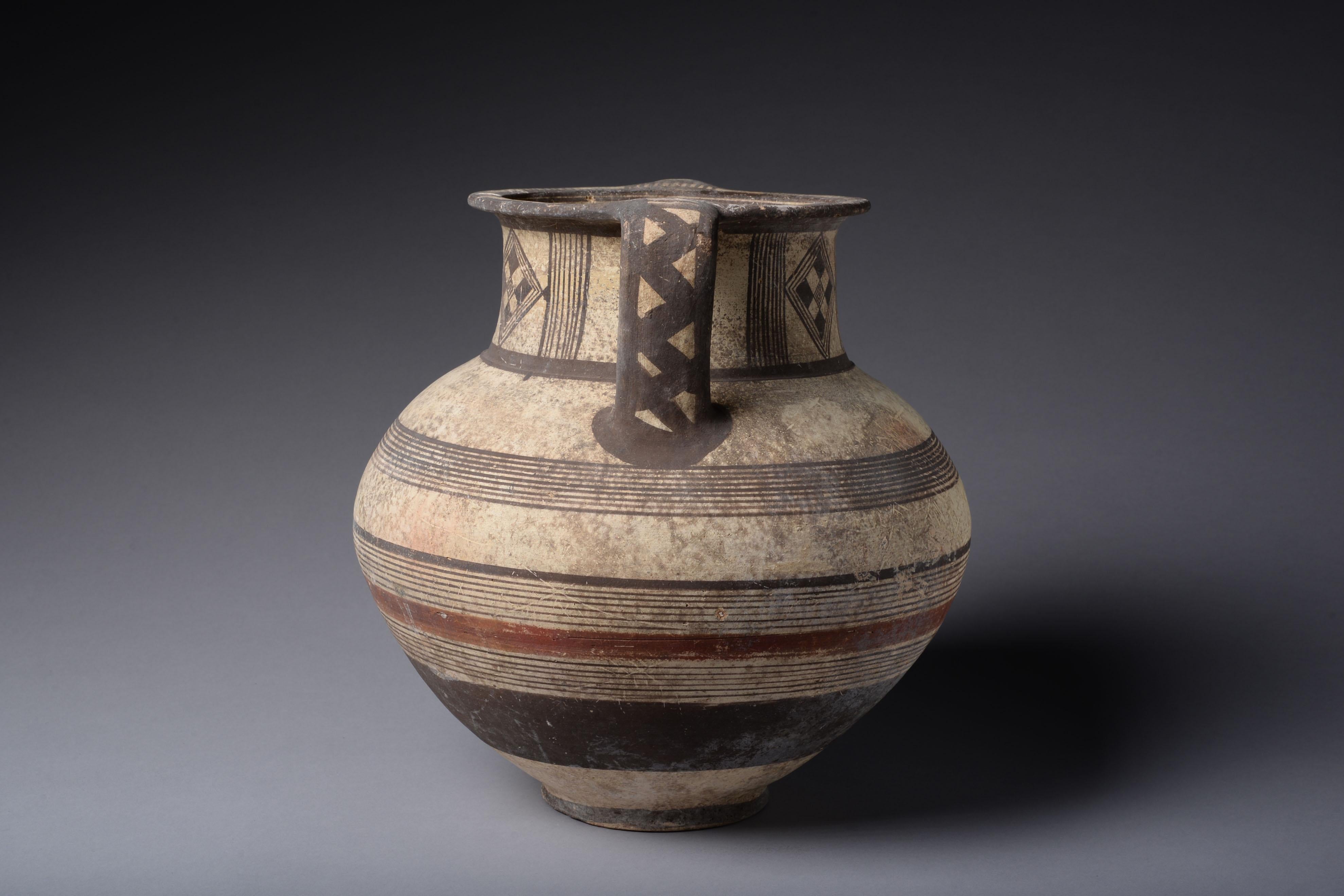 A beautiful polychrome amphora decorated with checks and bands of red and black paint, the pigments strikingly well preserved.

The strategic location of Ancient Cyprus at the crossroads of East and West made it an object of envy for its neighbours,