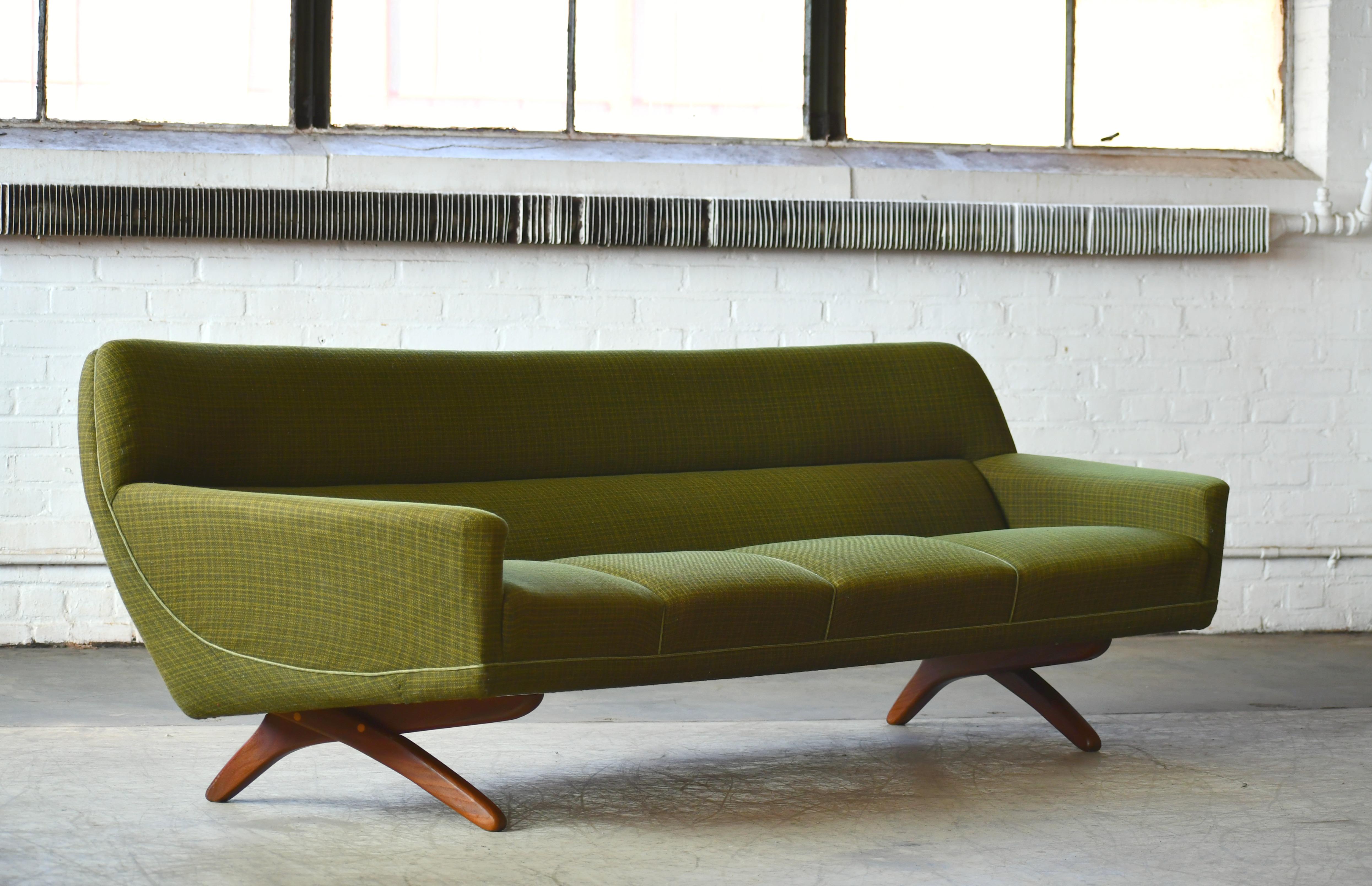 Stunning large Danish modern 1960s sofa designed by Illum Wikkelso and most likely manufactured by Soren Willadsen in the early 1960s. Cross leg design in solid teak typical for many of Wikkelso's iconic designs and beautiful rounded organic lines.